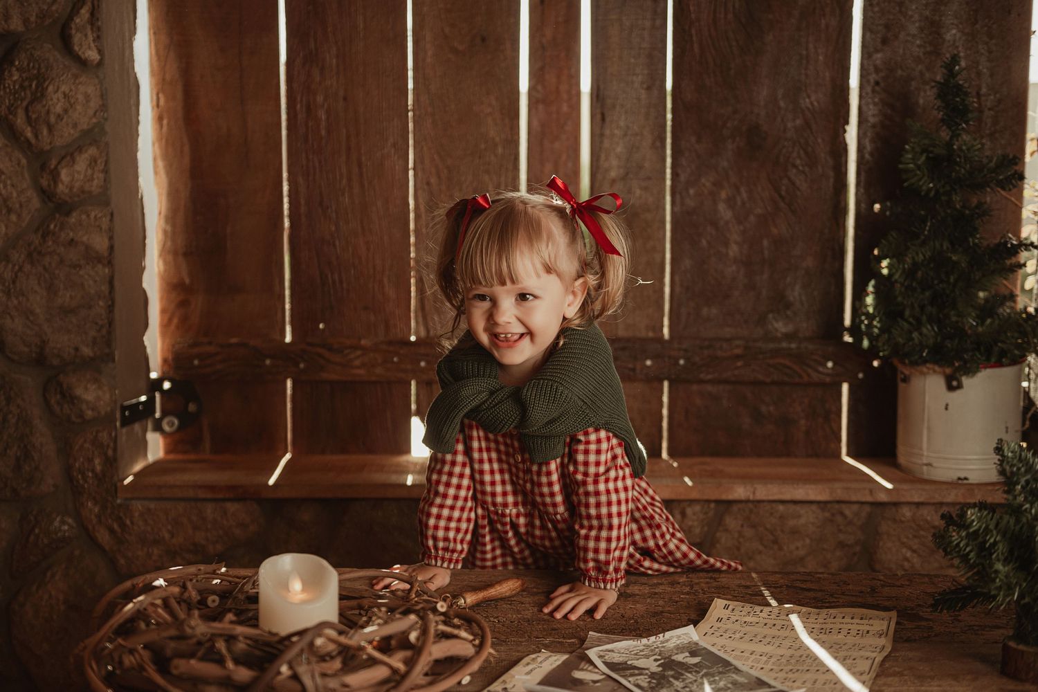 Rustic holiday setting with twinkling lights, wooden furniture and festive red plaid decorations.