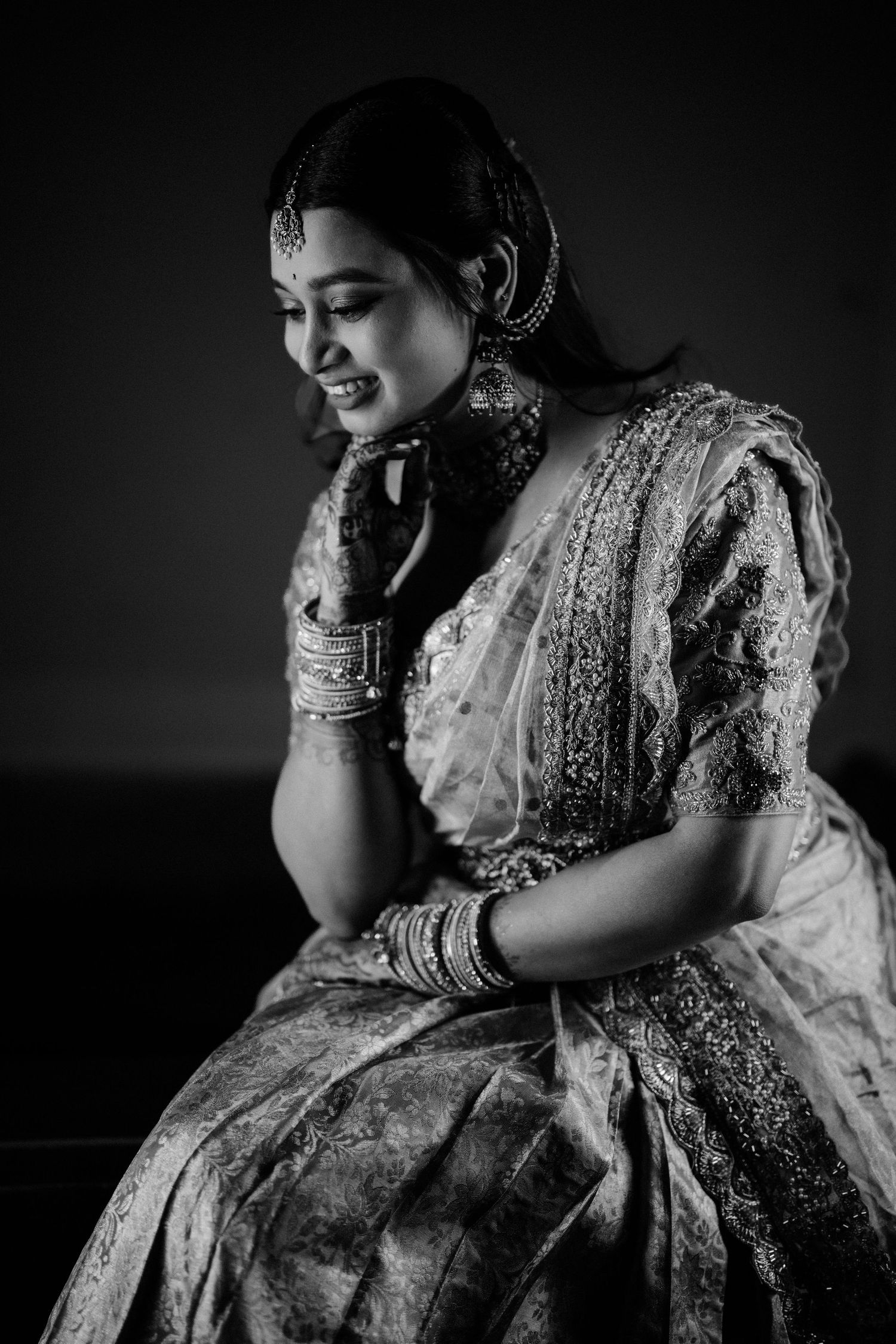 Monochrome portrait of bride in embellished saree and jewelry.