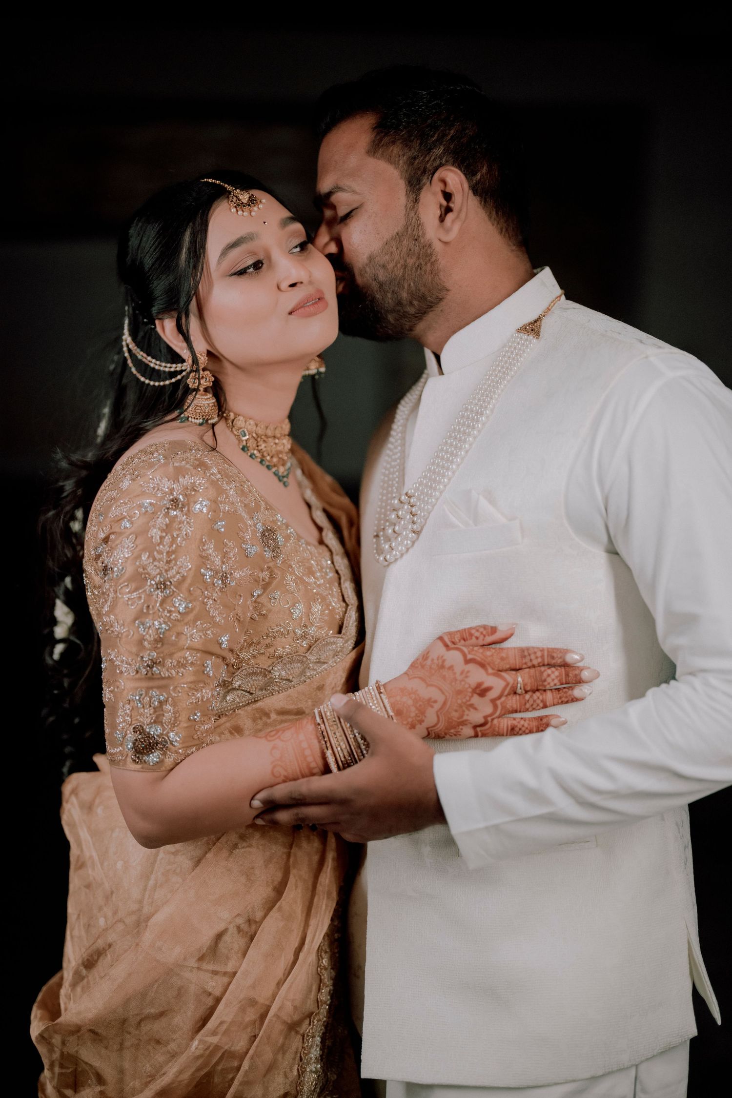 Romantic wedding portrait featuring traditional Indian formal wear in soft champagne and white tones.