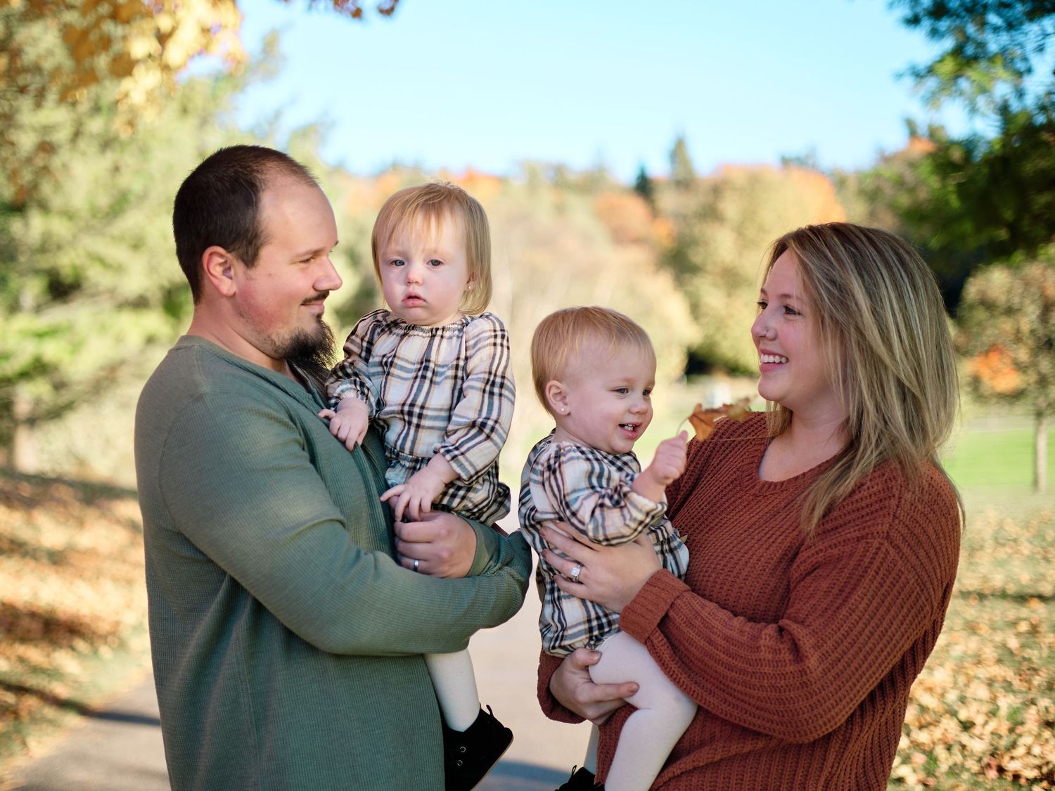 A sweet autumn outdoor portrait of a family of four surrounded by fall foliage.