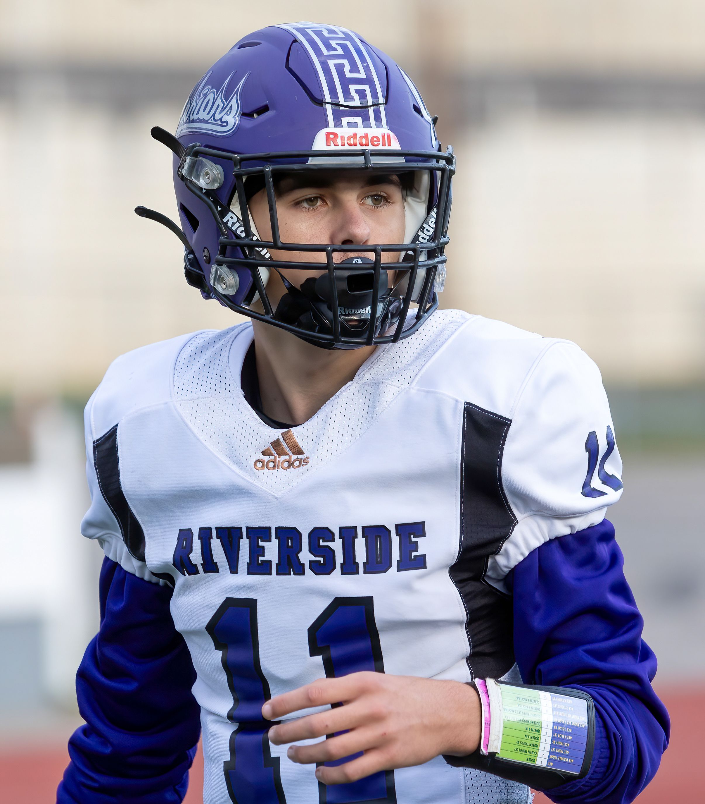 Football player in Riverside uniform number 11 wearing purple and white helmet.