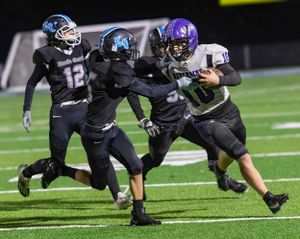 Riverside player breaks through defensive line while carrying football during game.