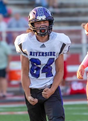 Riverside football player in white jersey number 64 on field during game.