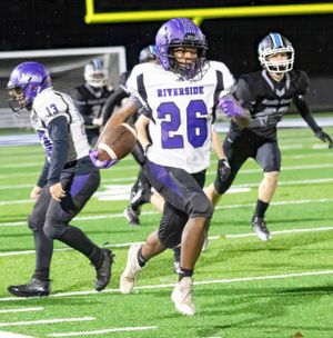 Running back in white jersey number 26 carries football during night game.