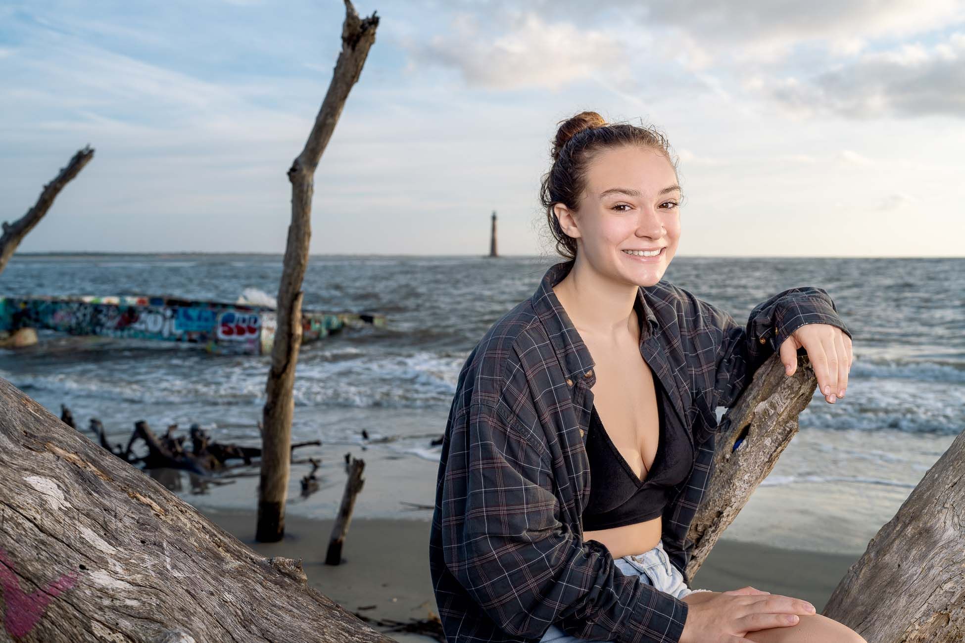 Senior portrait of high school student at Folly Beach with Morris Island Lighthouse near Charleston South Carolina