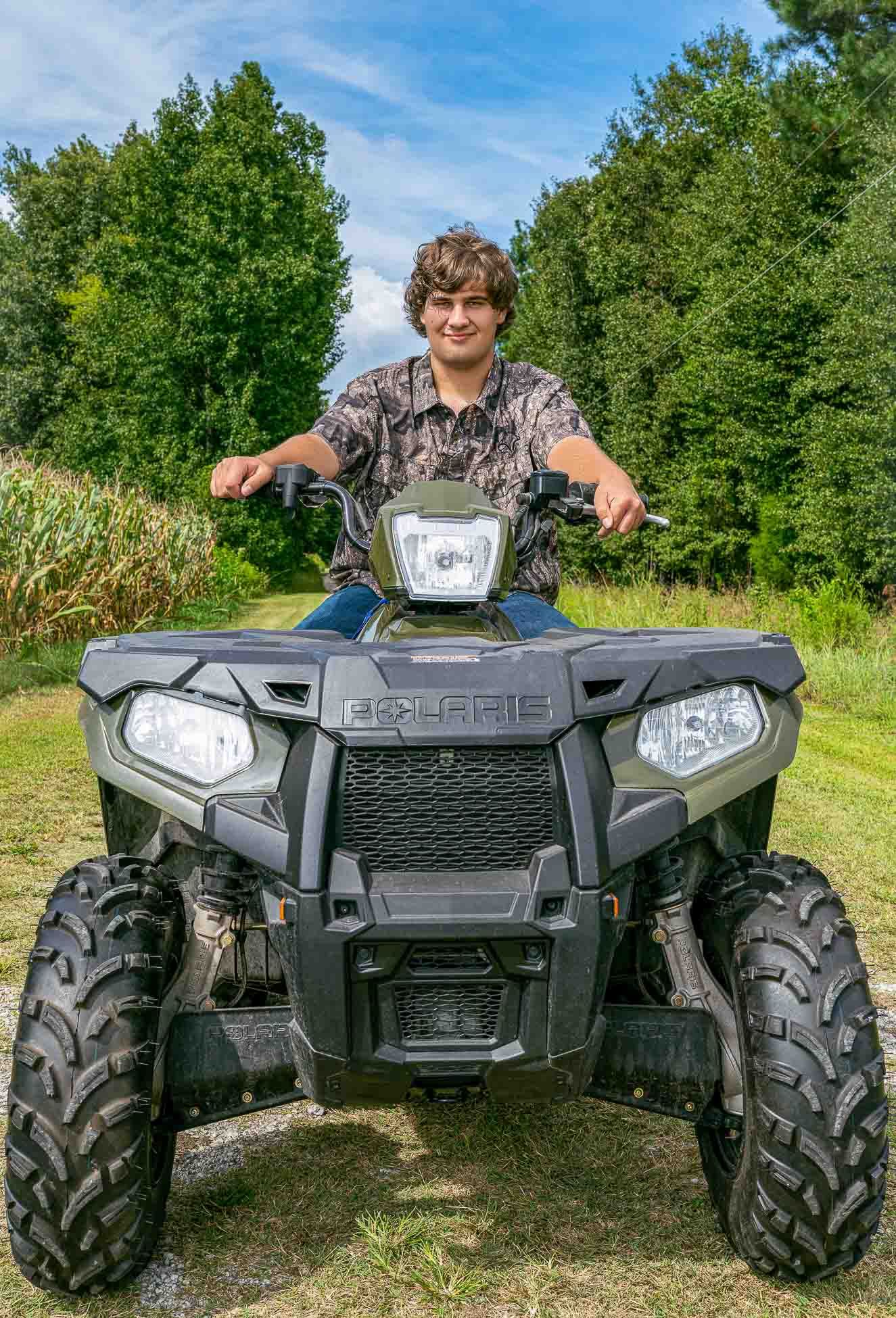 Summerville SC senior portrait of high school senior sitting on ATV in rural countryside setting