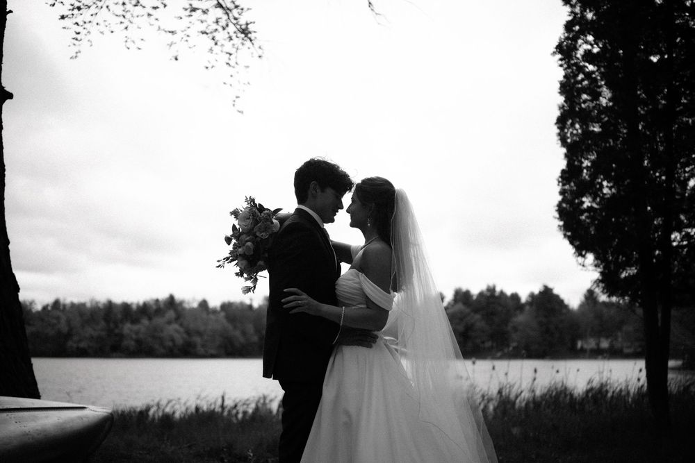A romantic silhouette of a couple embracing in front of a scenic landscape during sunset.