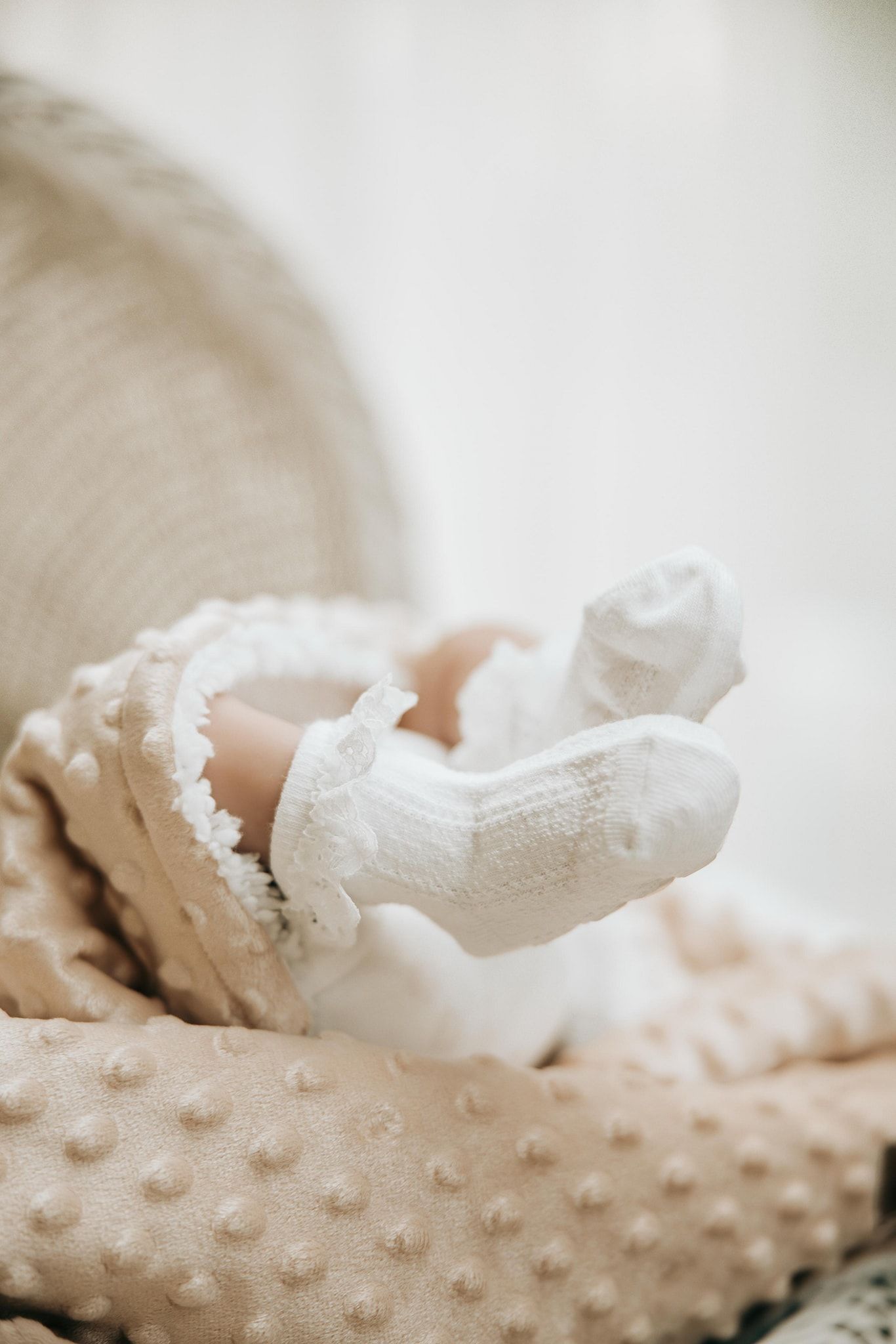 Close-up detail shot of delicate white lace fabric against a soft textured minky blanket.