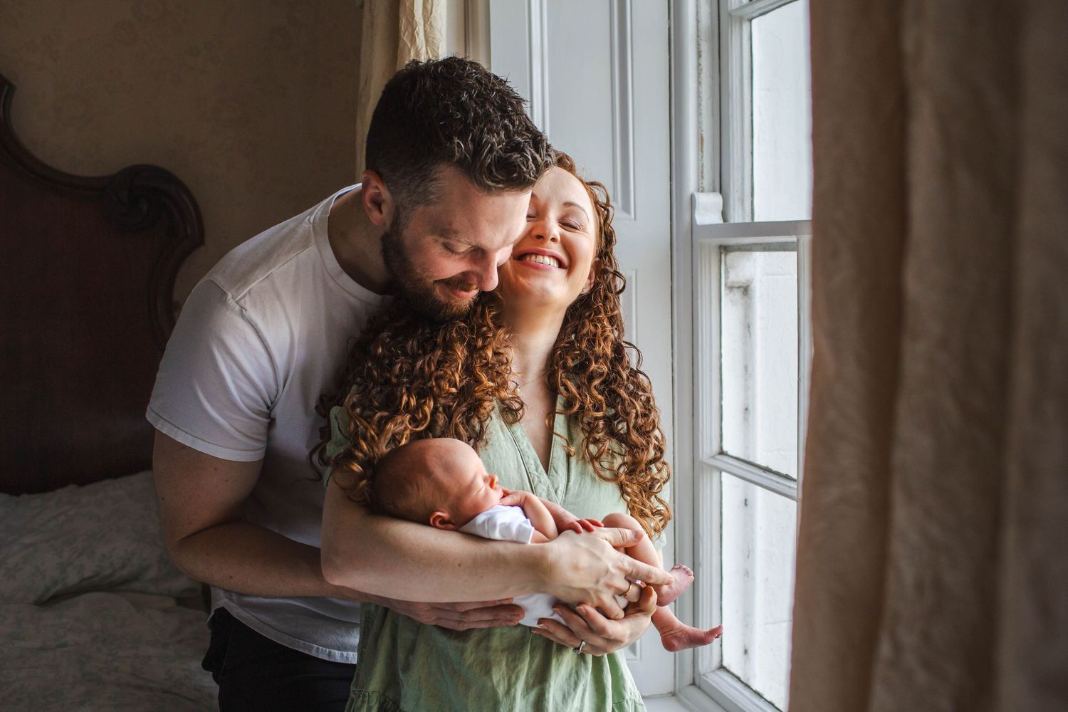 A series of tender moments between parent and newborn baby by a window in natural light.