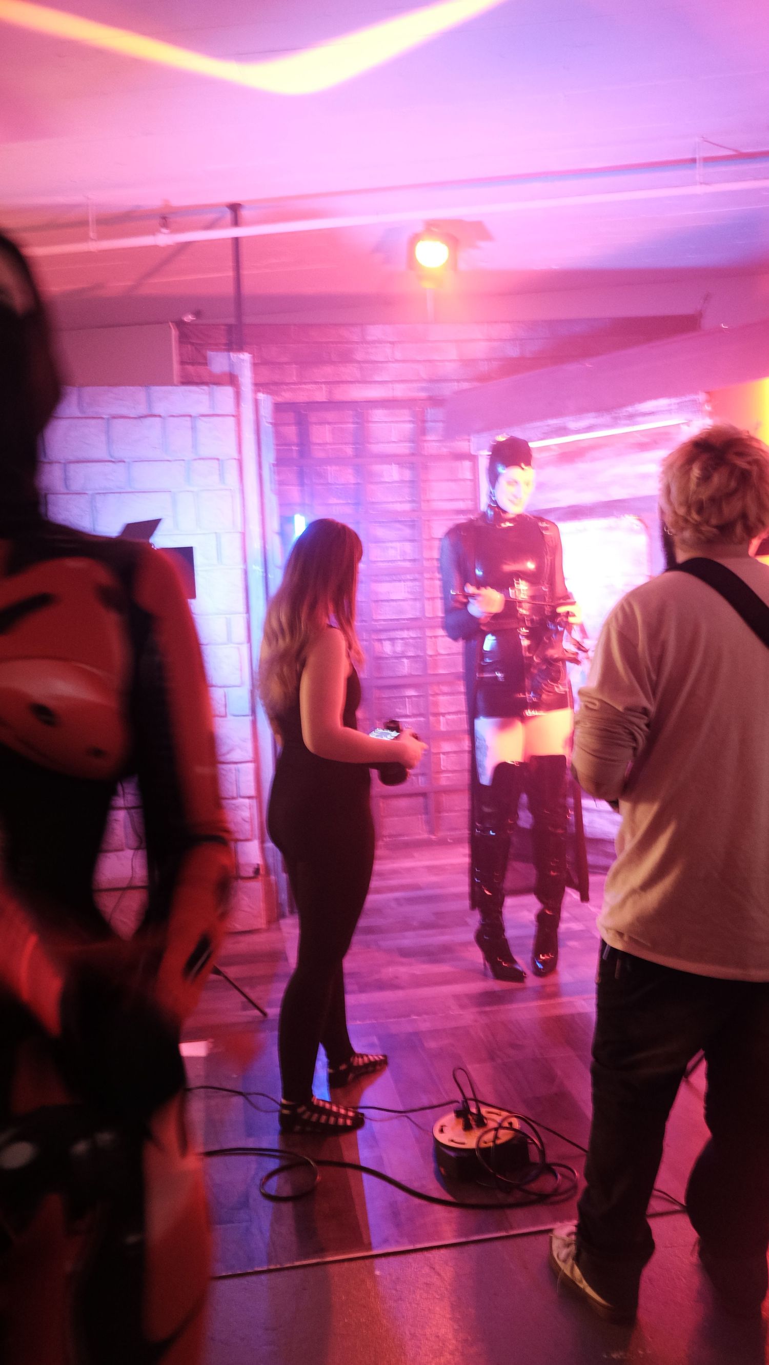 People playing laser tag in a dimly lit room with pink and purple lighting creating an atmospheric gaming environment.