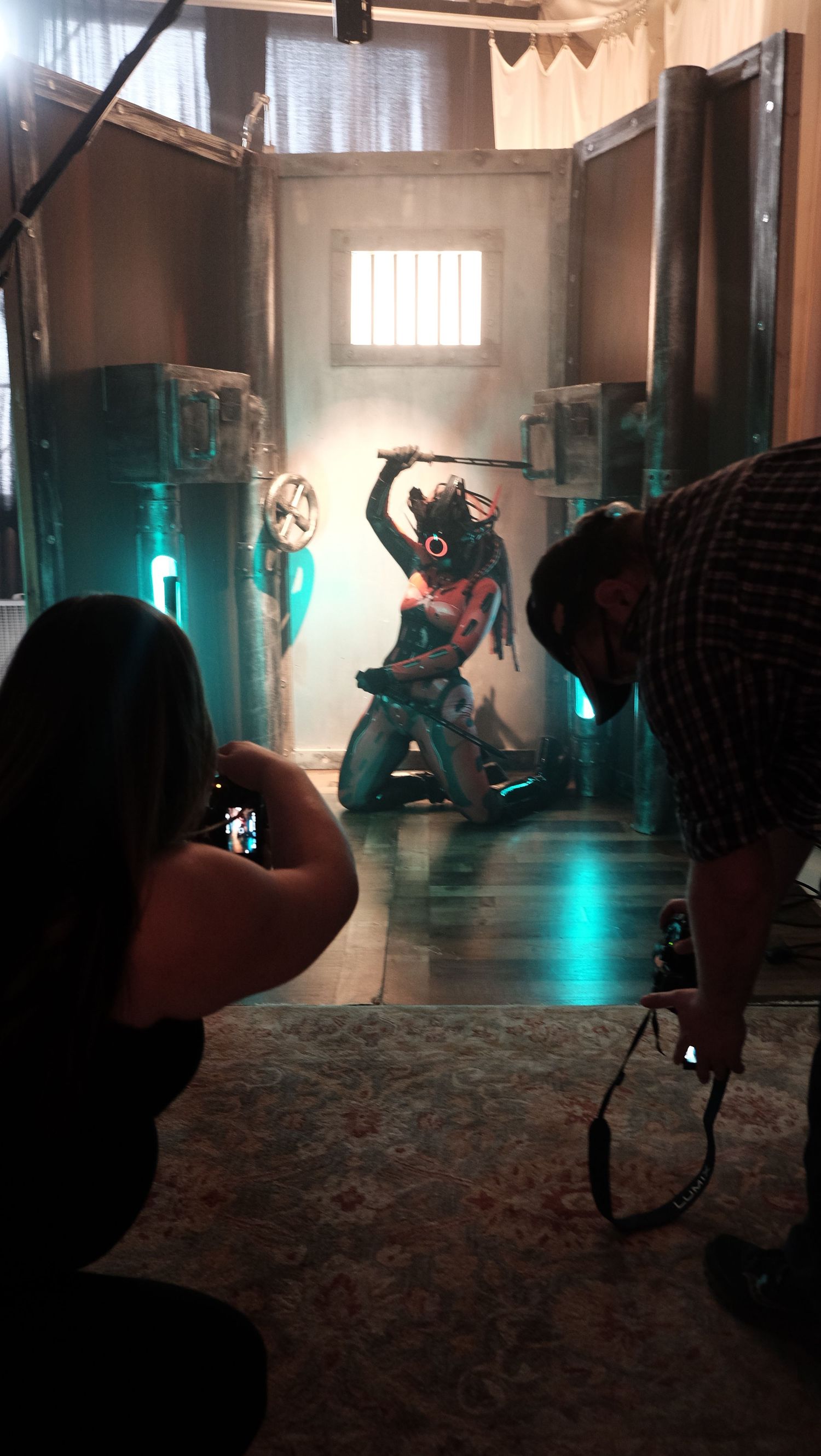 Silhouetted figures dance in a moody room with teal lighting and hanging bunting decorations creating an atmospheric scene.