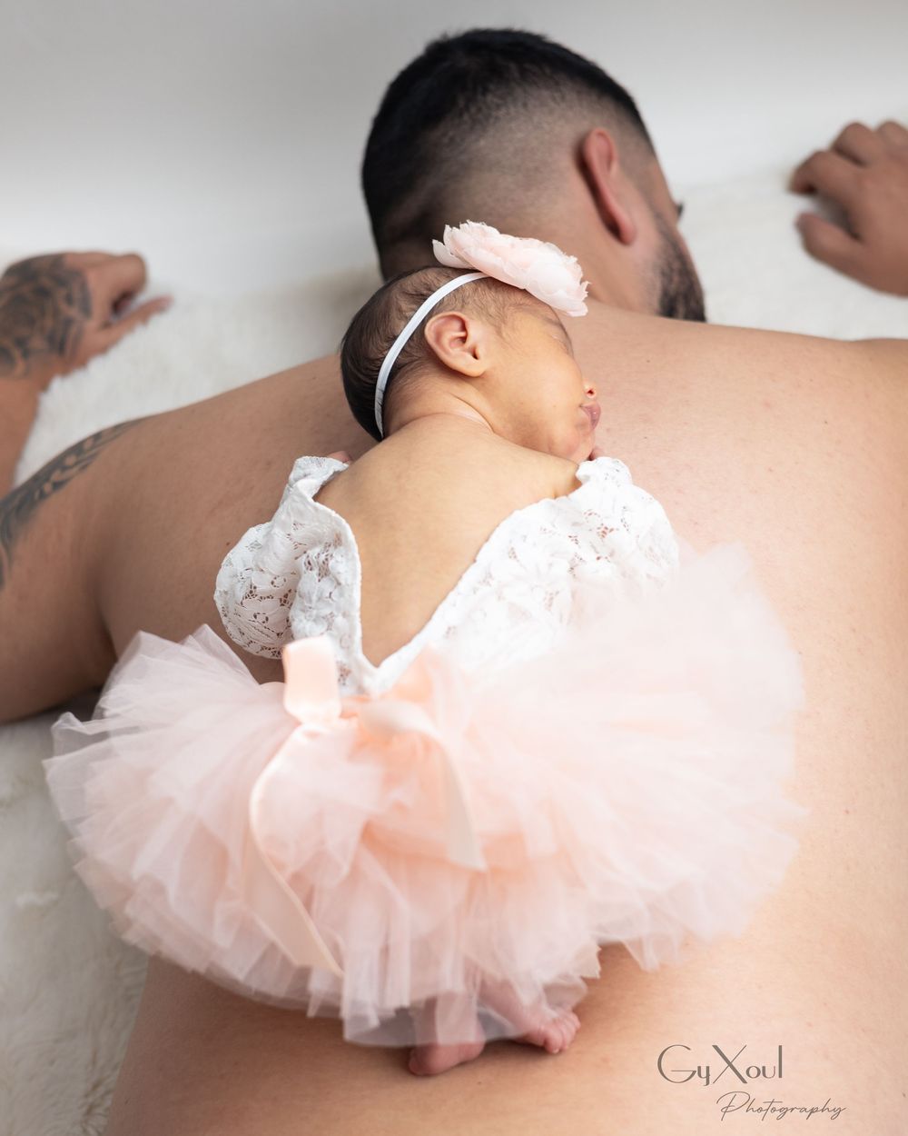 Baby wearing a pink tutu diaper cover is photographed from different angles in a minimalist setting.