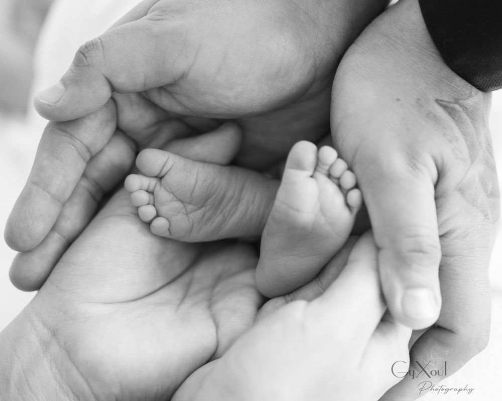 Black and white close-up series of tiny newborn baby feet and hands.