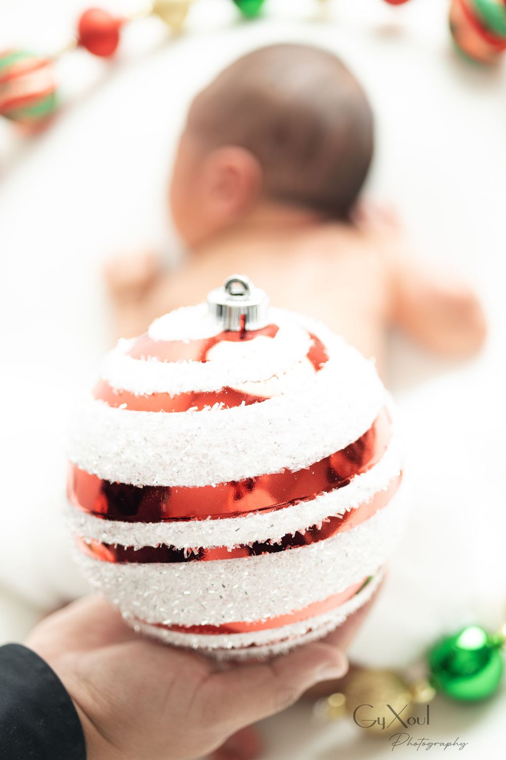 Red and white striped Christmas ornaments with sparkly snow-like texture against a blurred festive background.