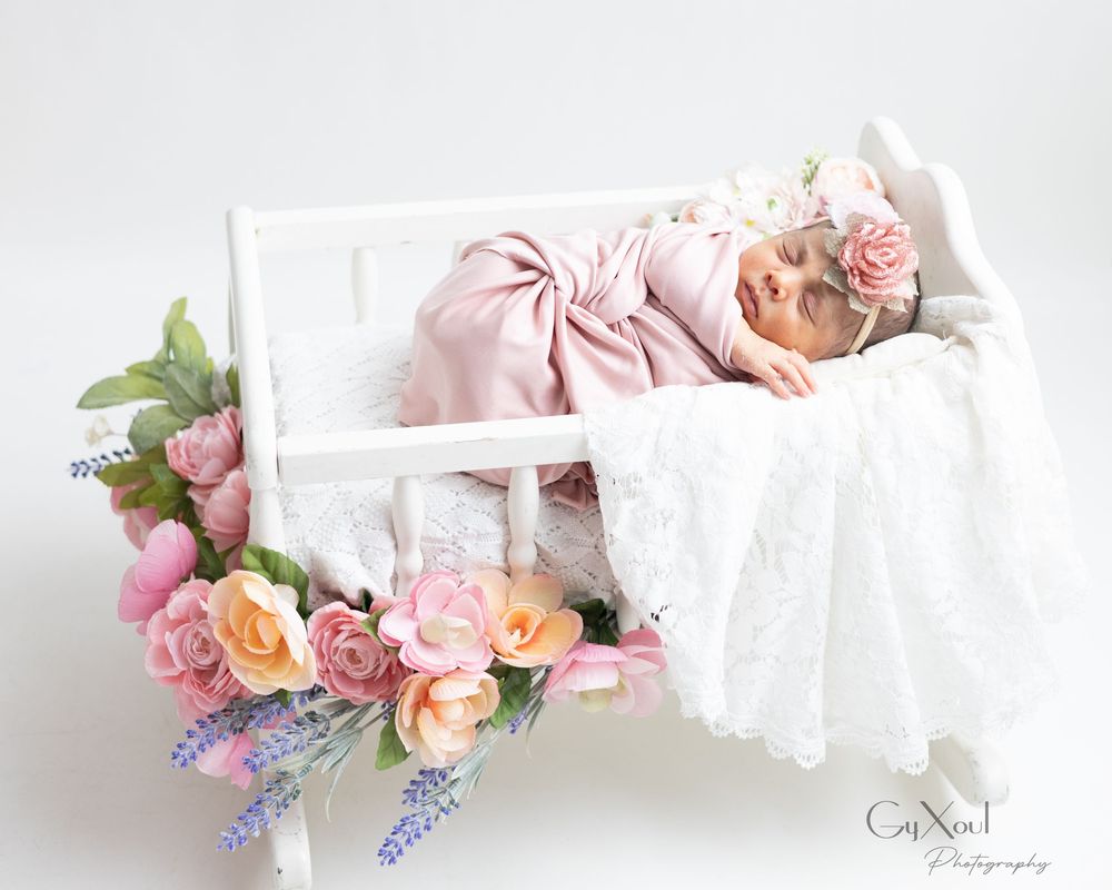 Delicate floral crowns with pink roses and purple flowers arranged on white fabric.