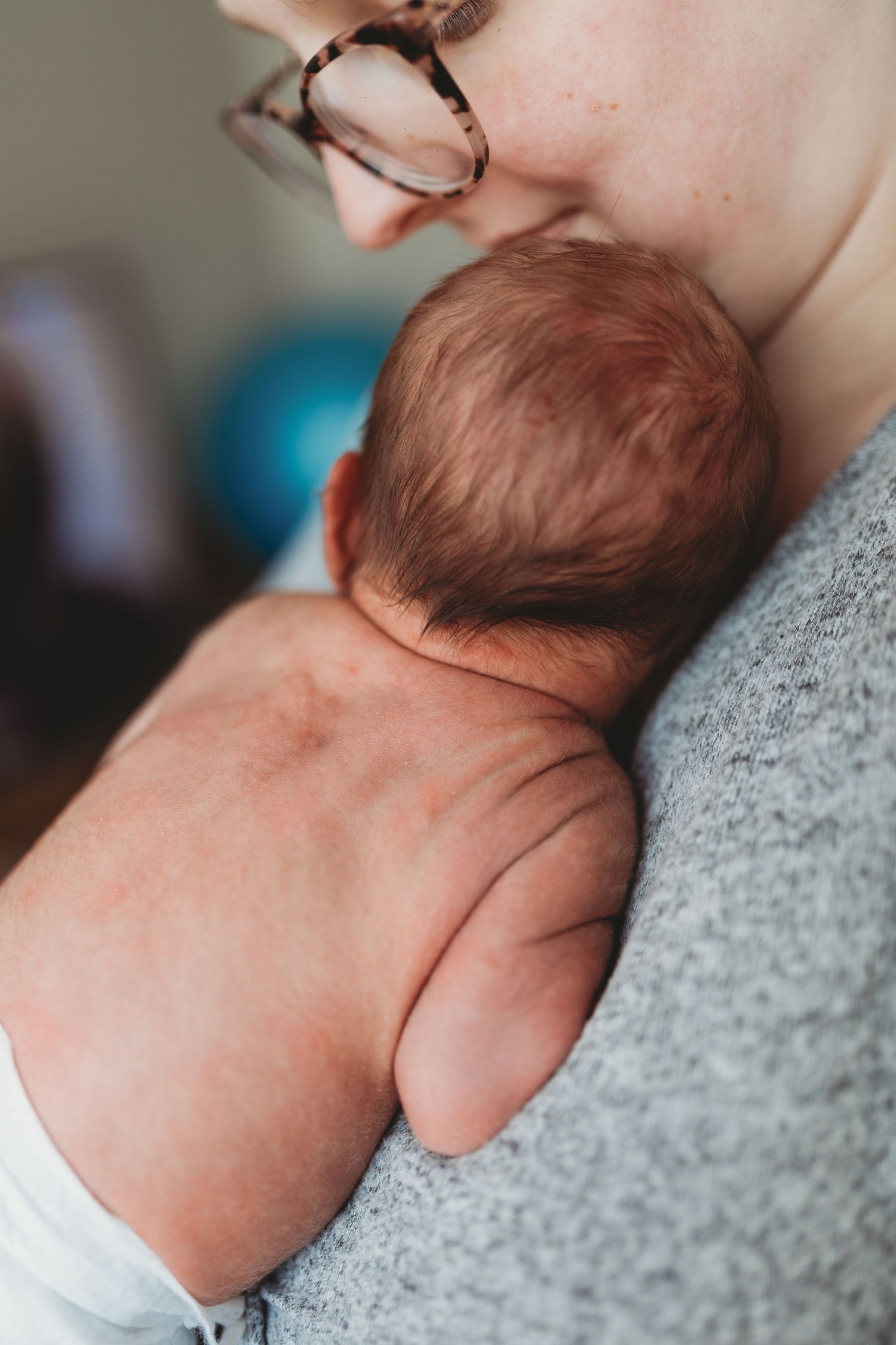 A series of intimate close-up shots showing a newborn baby resting peacefully against a gray sweater.
