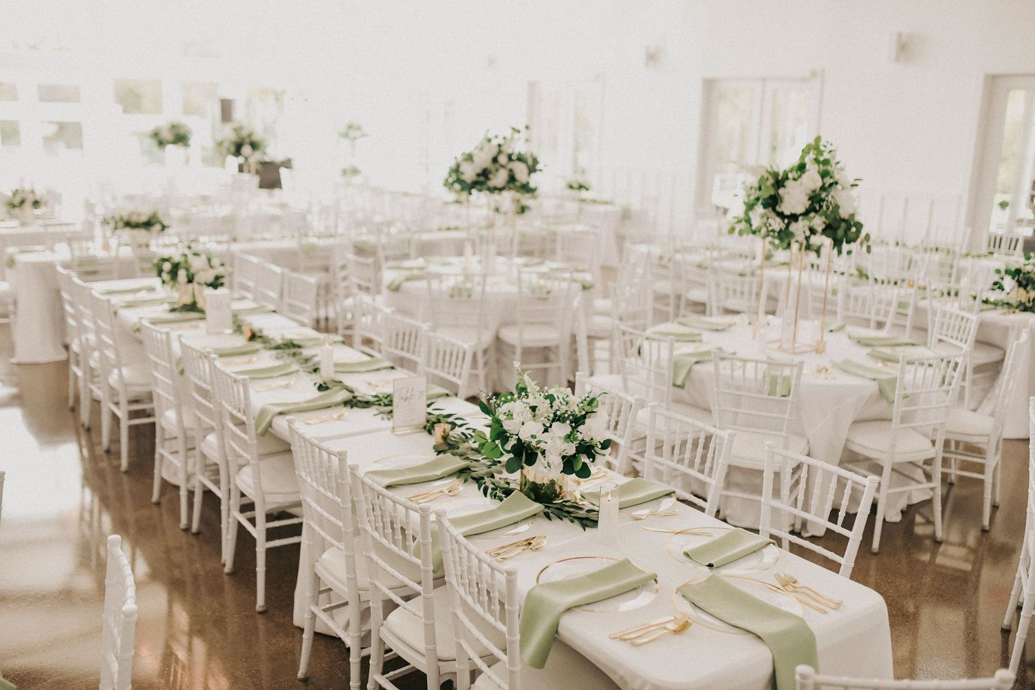 Spring wedding reception decor with greenery and gold accents