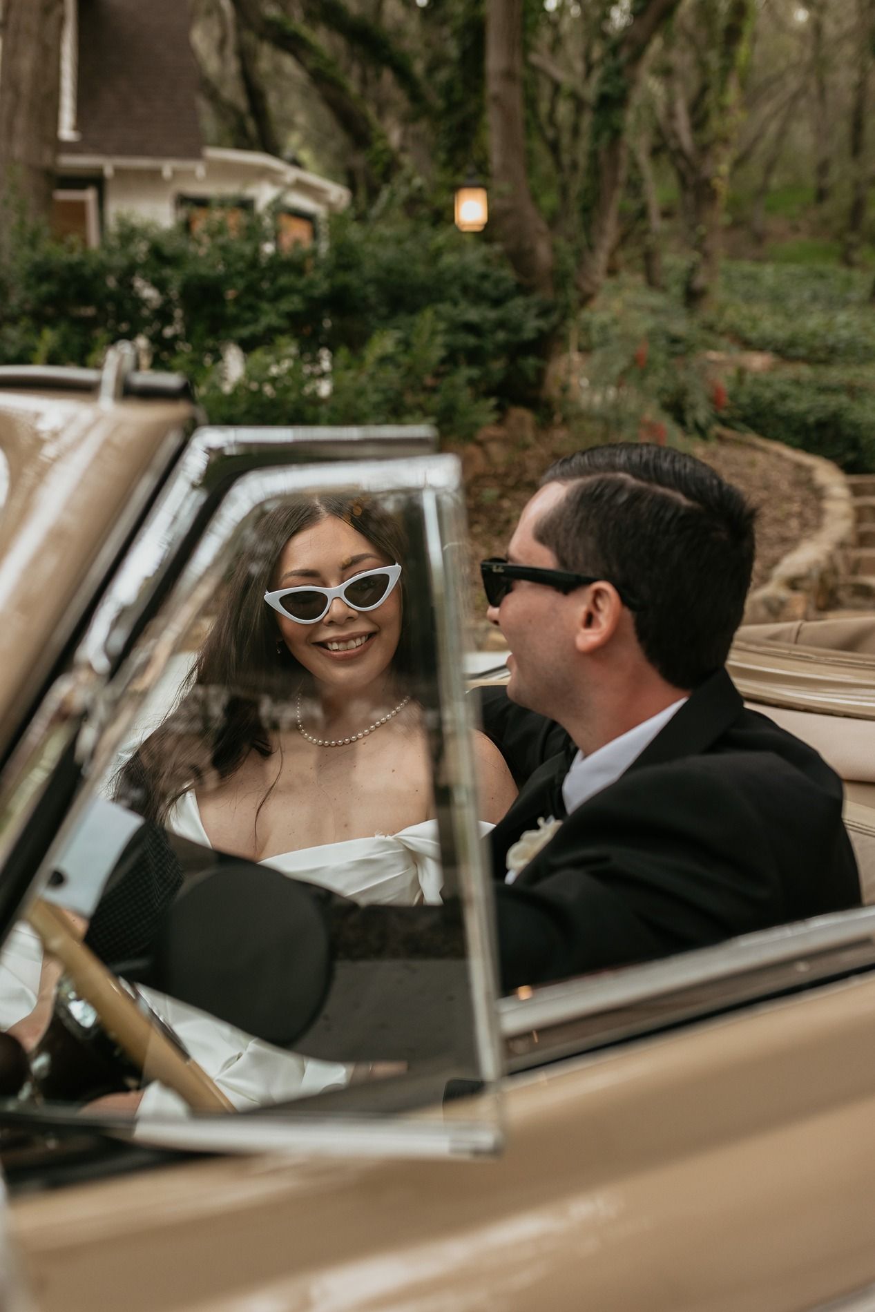 A vintage car shows a romantic wedding couple moment through multiple frames in a cream-colored classic automobile.