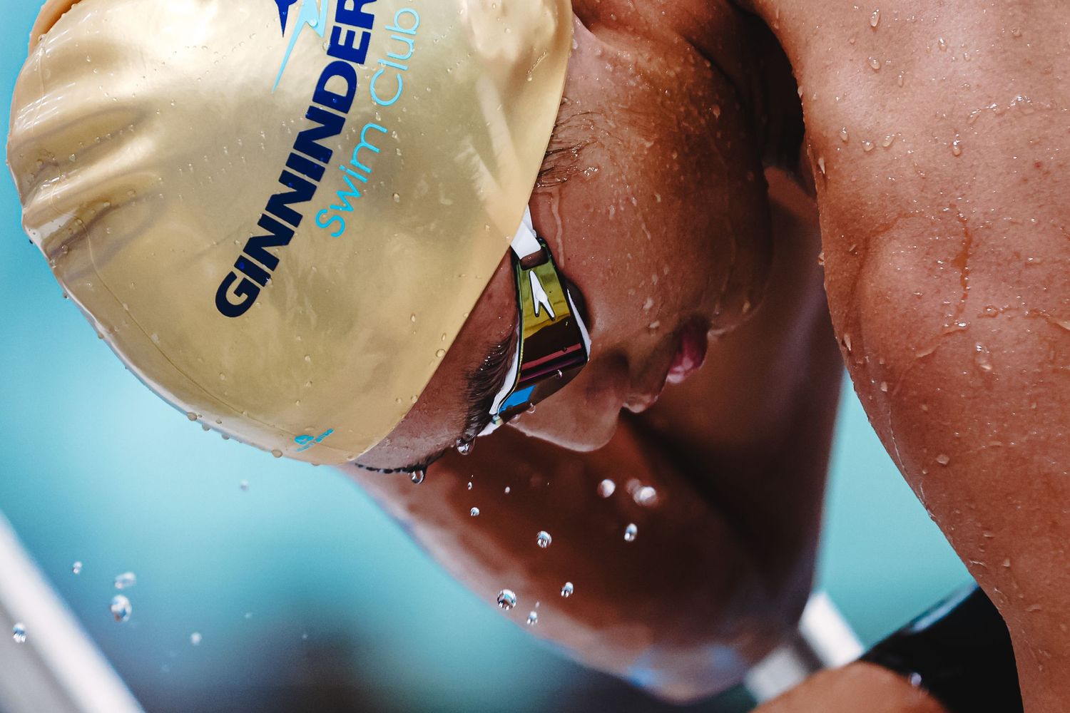 Competitive swimmer performing breaststroke in a pool lane during a race.