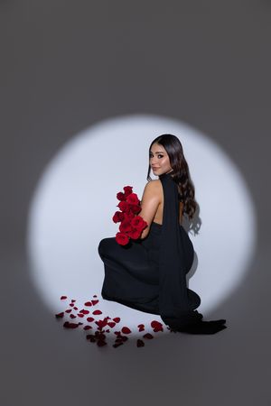 A dramatic portrait series shows a figure in black against a spotlight with scattered red rose petals creating an artistic mood.