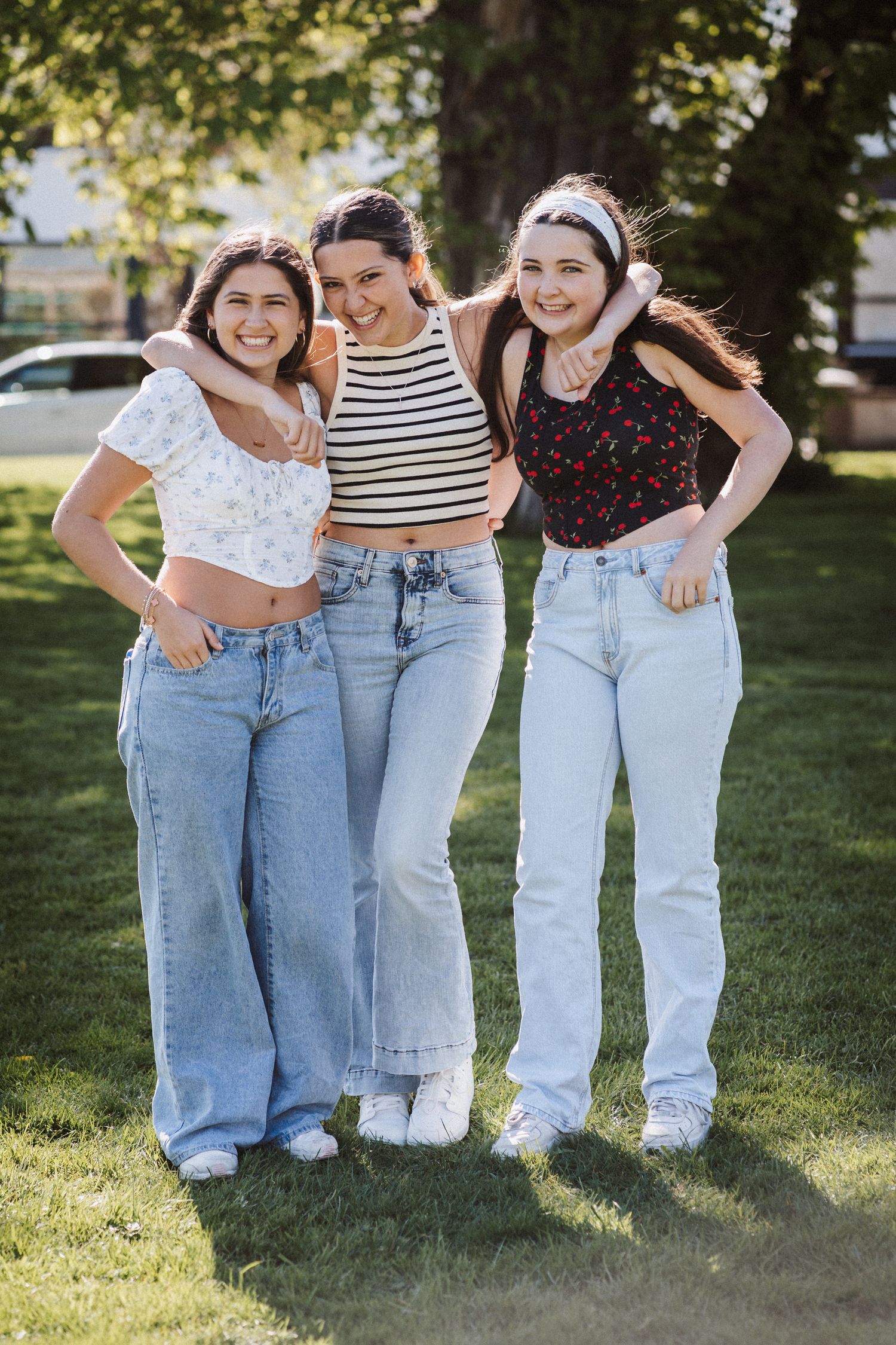 A series of five photos showing people wearing matching light blue jeans and casual tops standing together outdoors.
