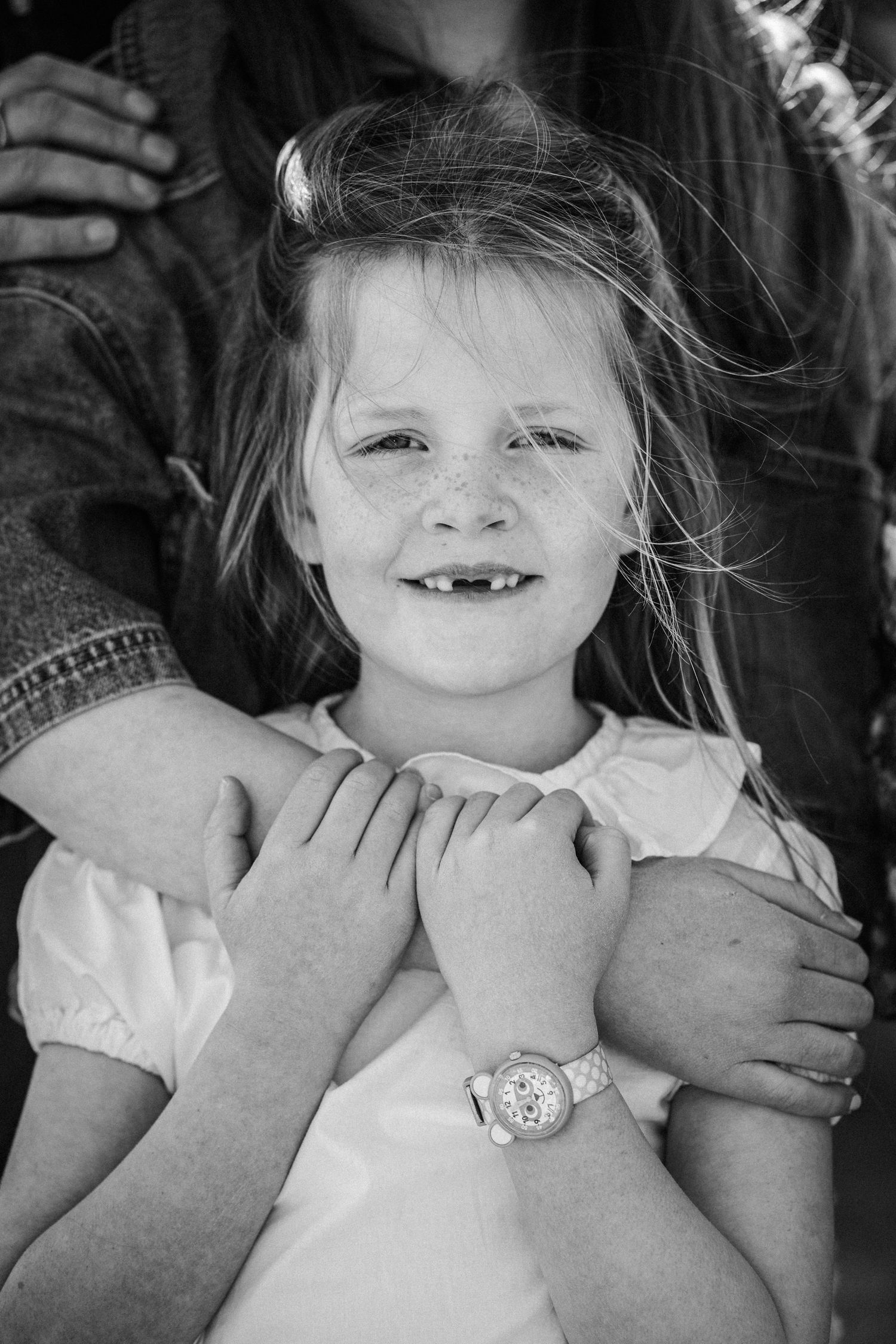 Black and white photo series showing a child's face being playfully squeezed by adult hands.