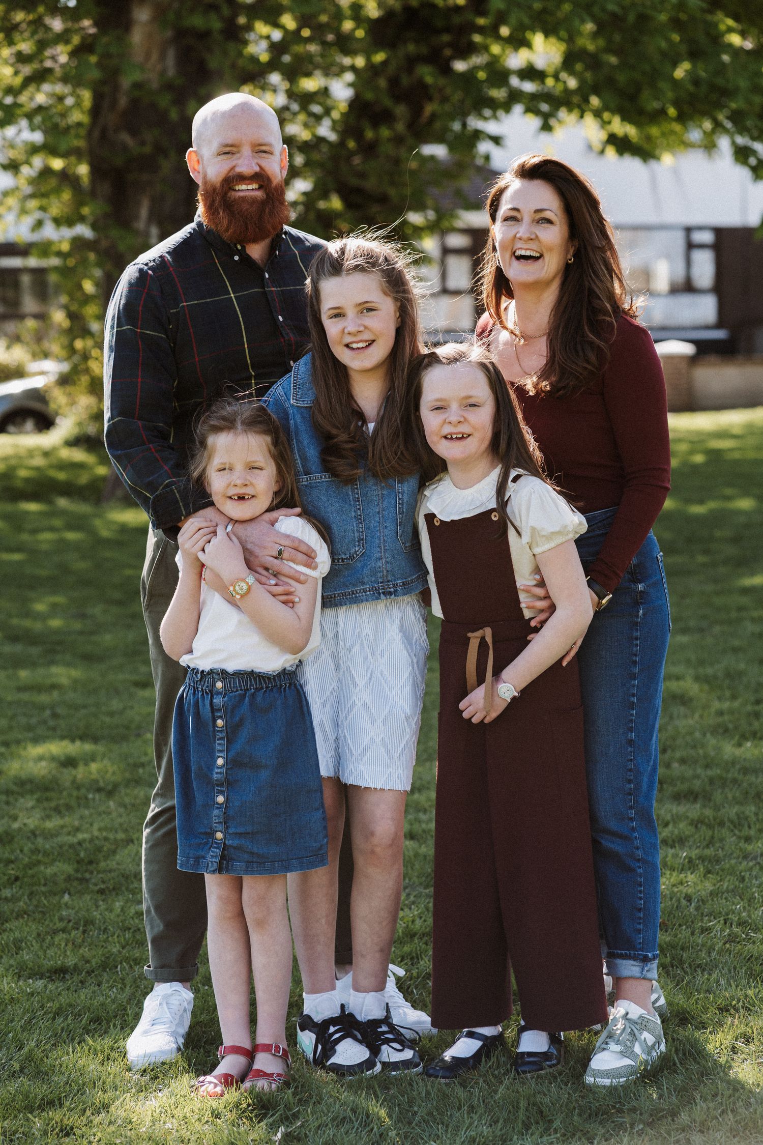 A candid outdoor family photo series showing joyful interactions on a sunny day in a grassy area.