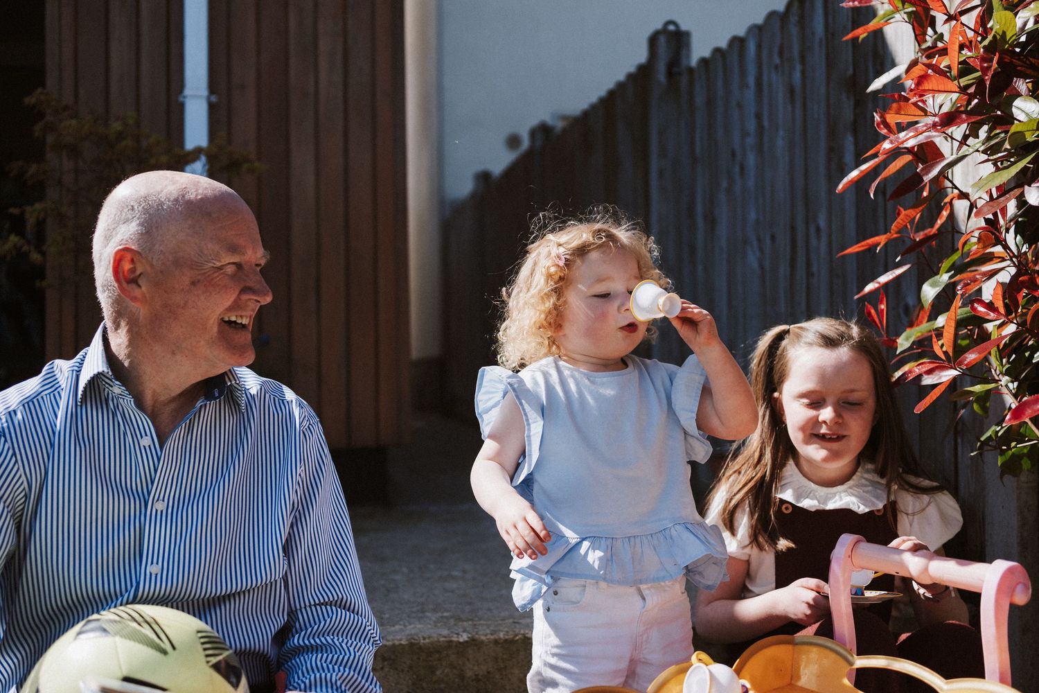 A sequence of candid moments showing people enjoying time together in a backyard garden setting with autumn foliage.