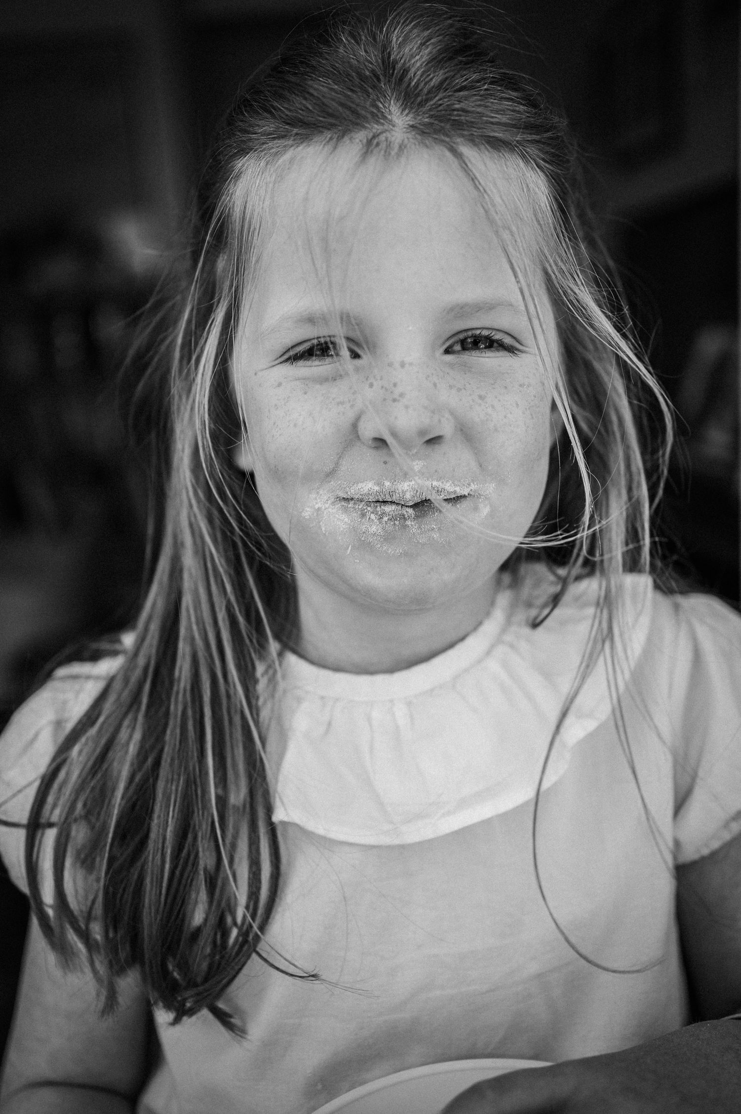 Black and white portrait sequence showing a child with chocolate smeared around their mouth, wearing a white shirt.