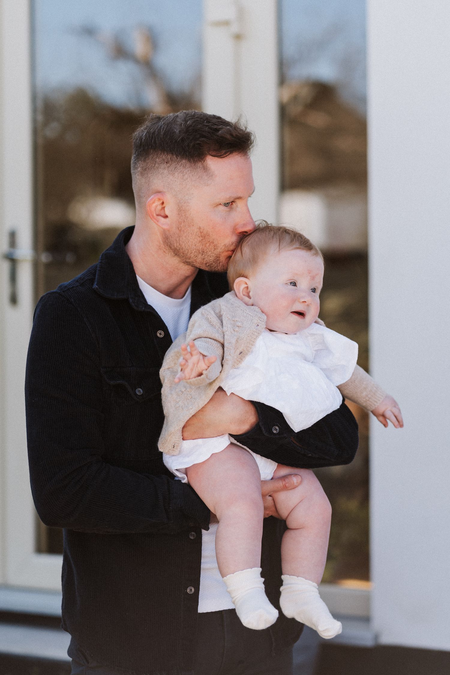 A series of candid shots showing tender moments between a parent and baby on a porch.