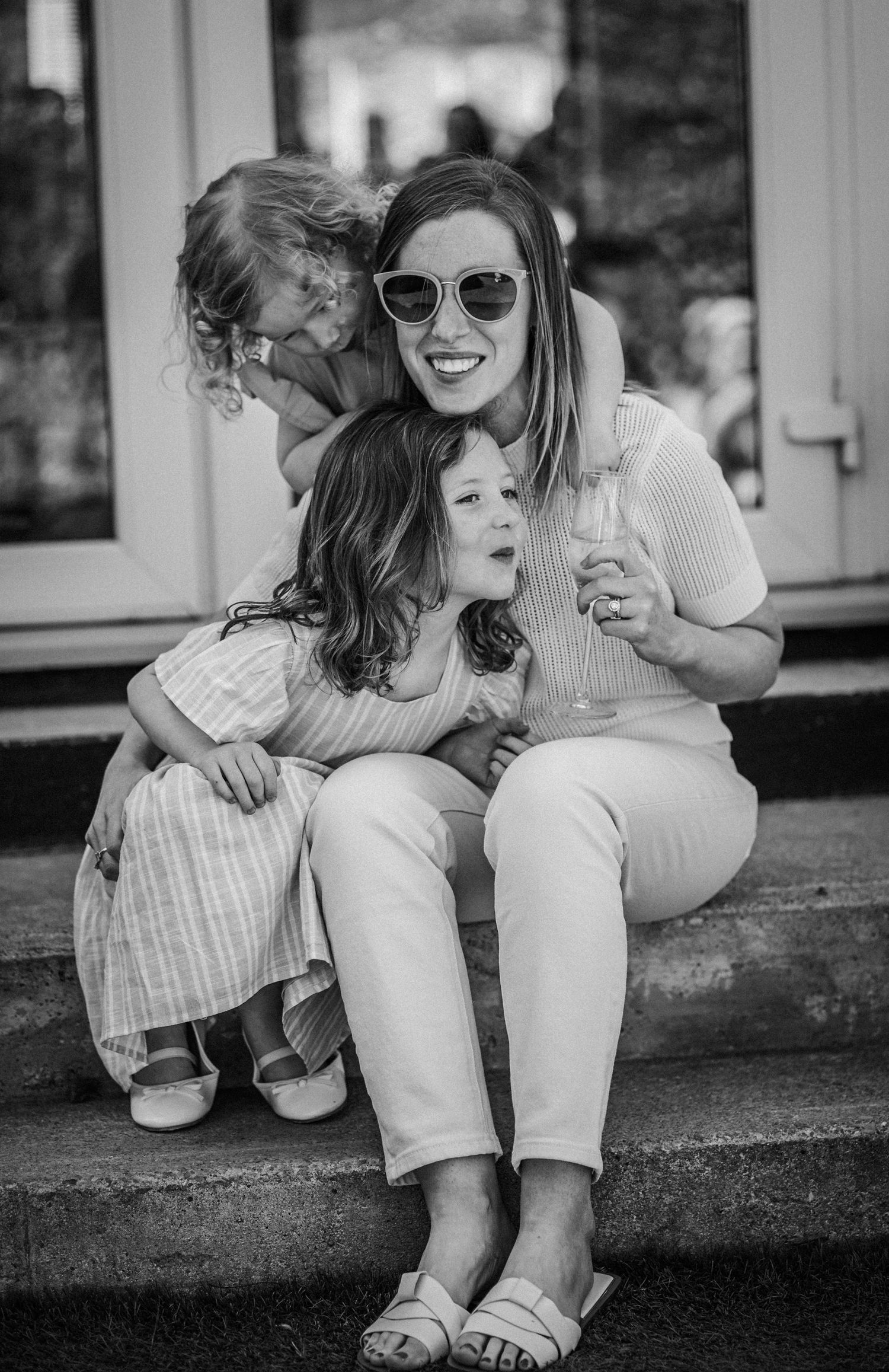 Black and white images of a mother and child sitting together on outdoor steps sharing joyful moments.