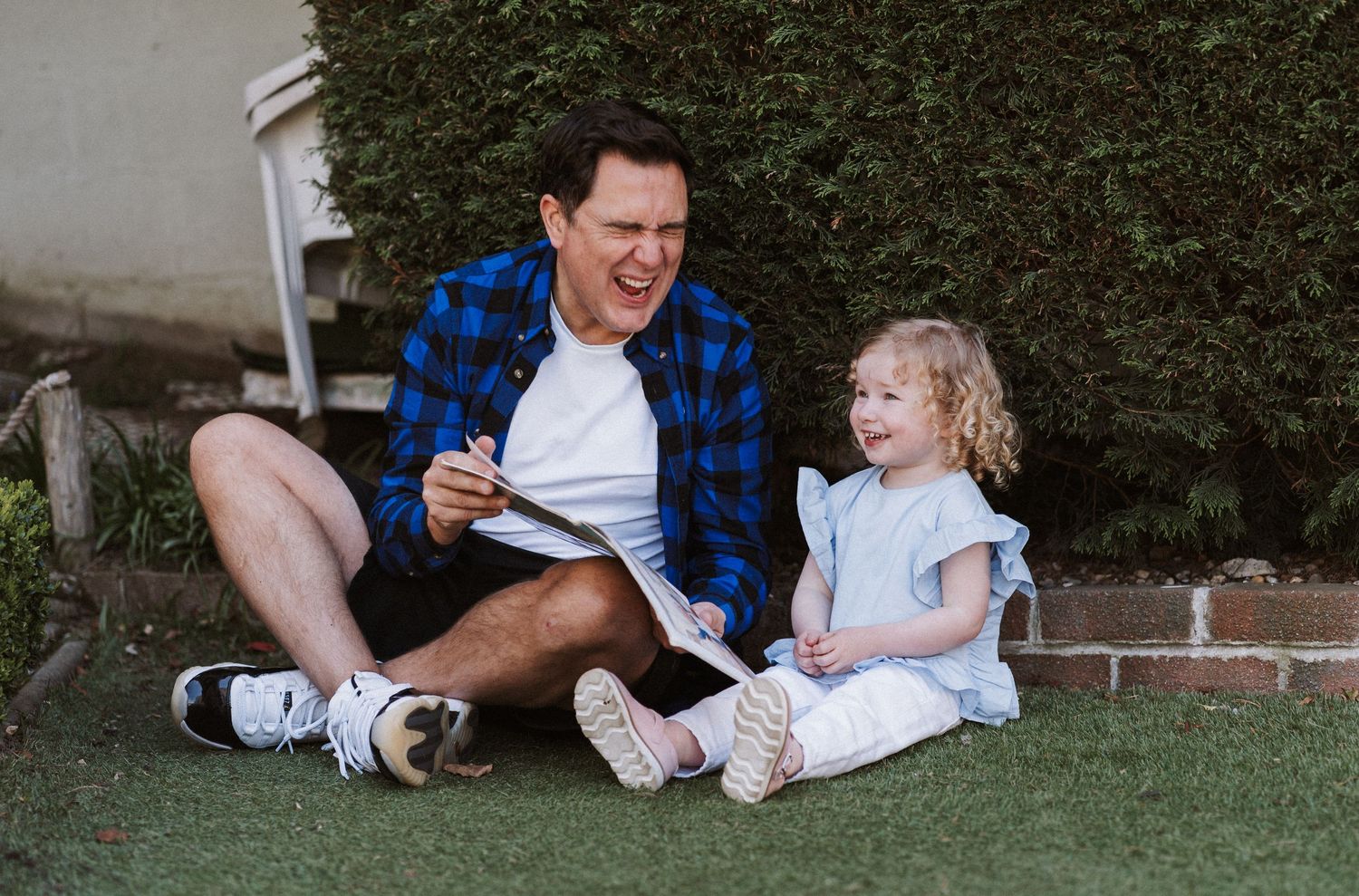 A series of candid outdoor family moments captured in a grassy backyard setting during a casual photoshoot.