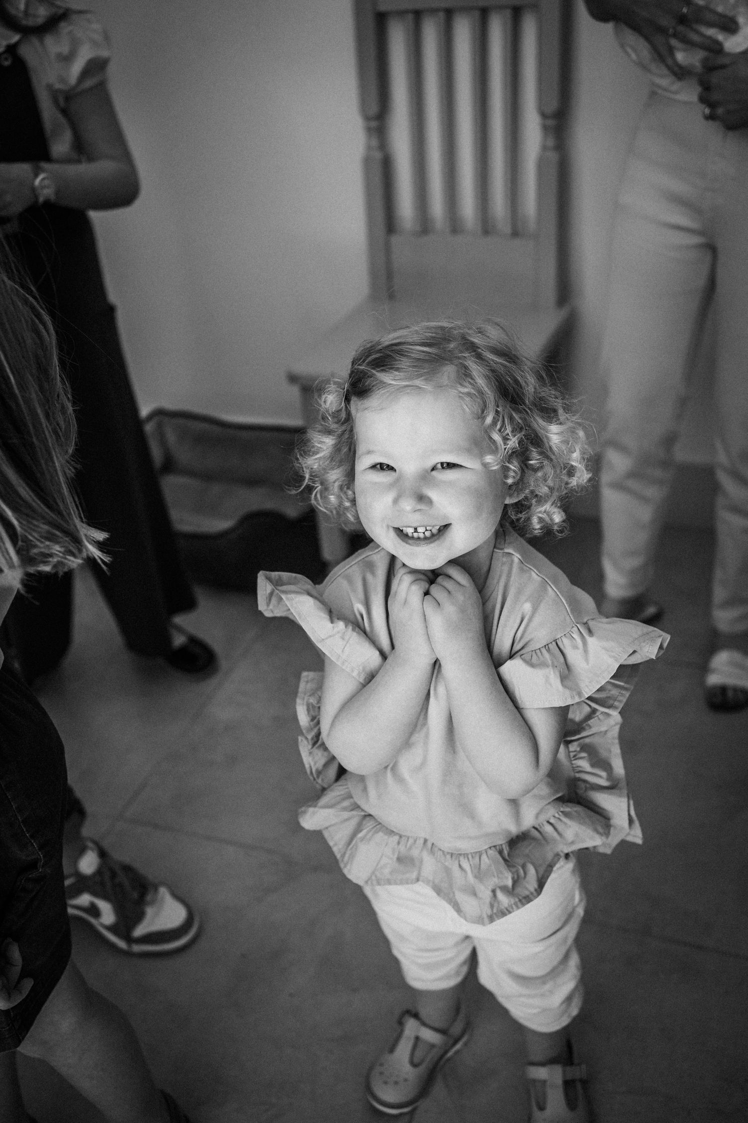 Black and white photo series showing a child in a dress dancing and playing with joyful expressions.