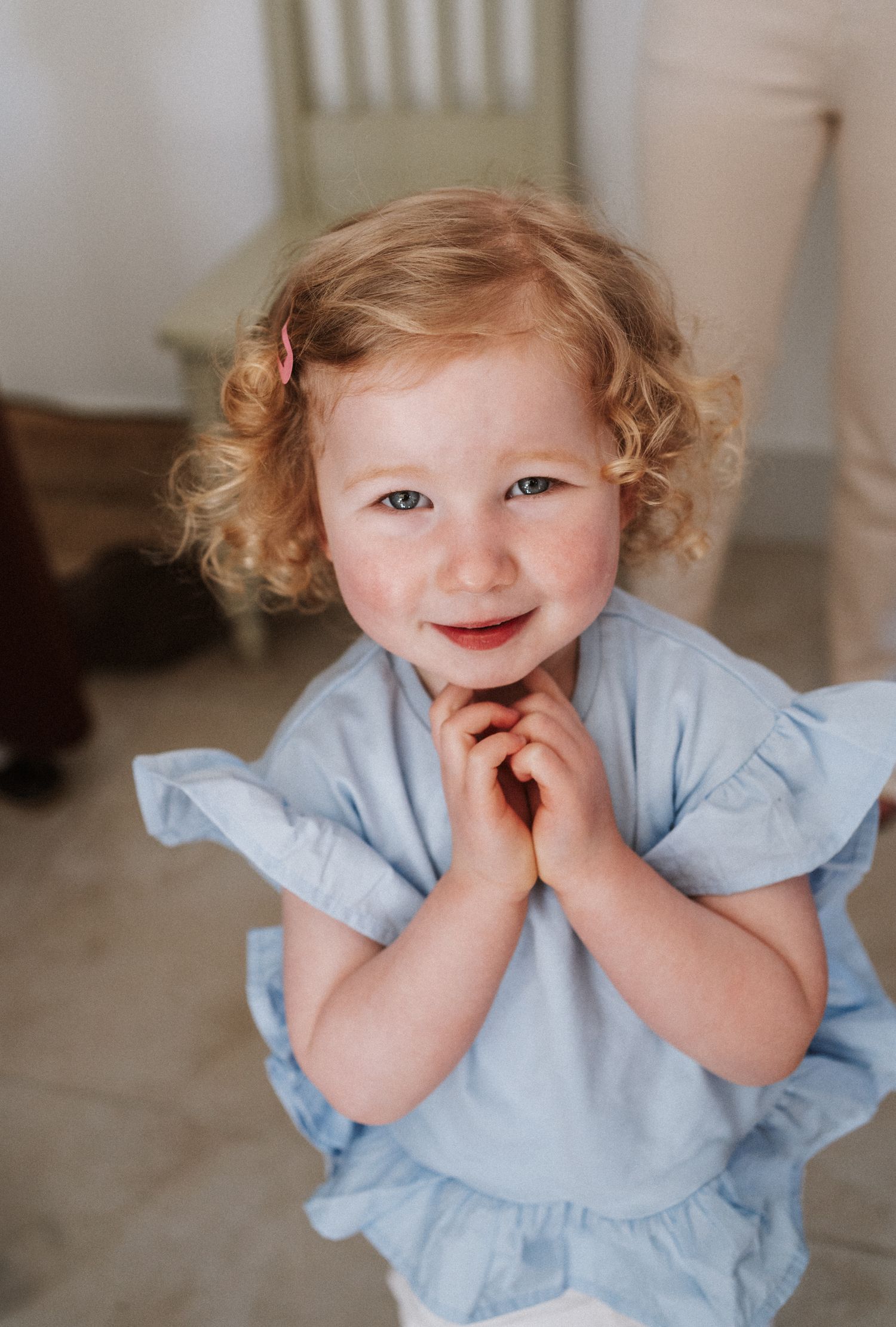 A child in a light blue dress shows a range of playful expressions while posing for a series of photos.