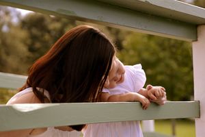 A mother and daughter resting their heads on each other and looking out