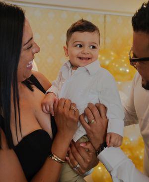 A baby being held by a woman and smiling