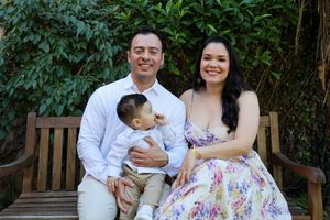 Two parents sitting with their baby while he looks up at his mother