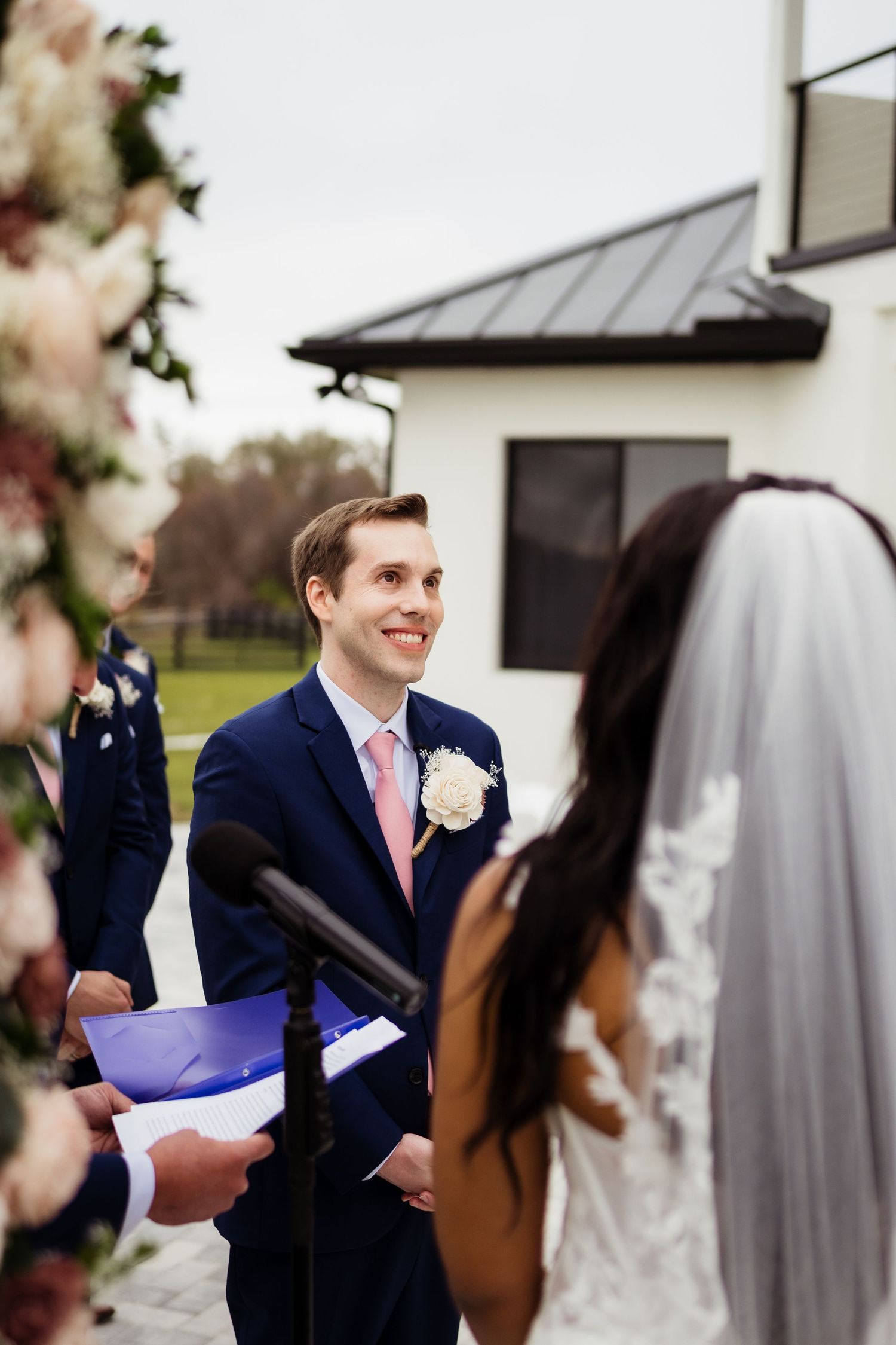 A wedding ceremony moment captured showing the exchange of vows between the couple at an elegant venue.