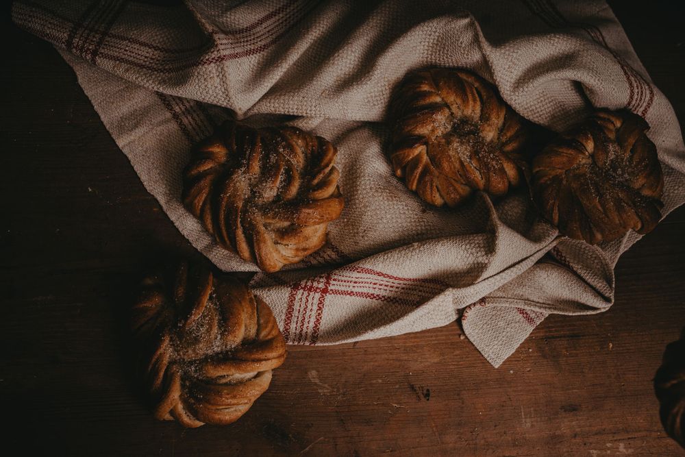 Freshly baked chocolate croissants arranged on a rustic wooden surface with a linen cloth.