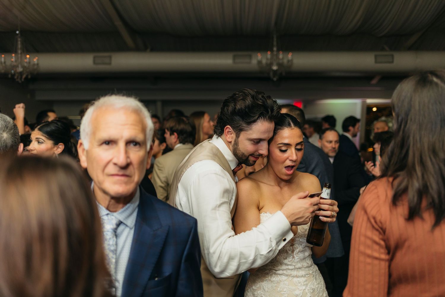 wedding couple reviewing a polaroid sneak peek in the middle of the dance floor