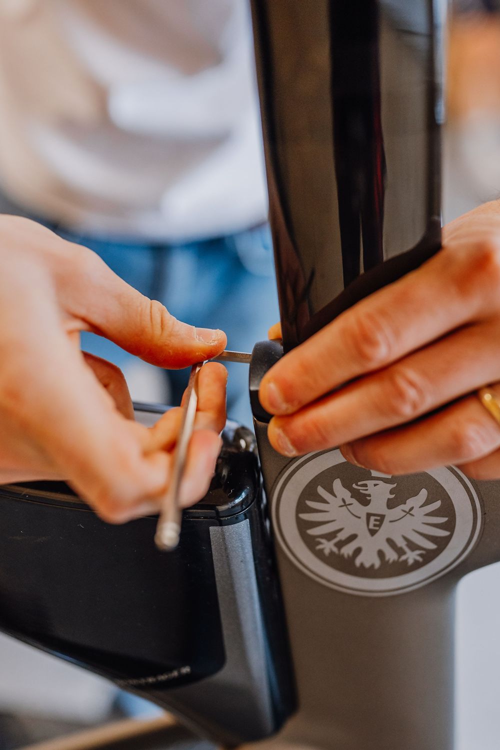 Close-up sequence showing hands adjusting settings on a bike component with an eagle emblem.