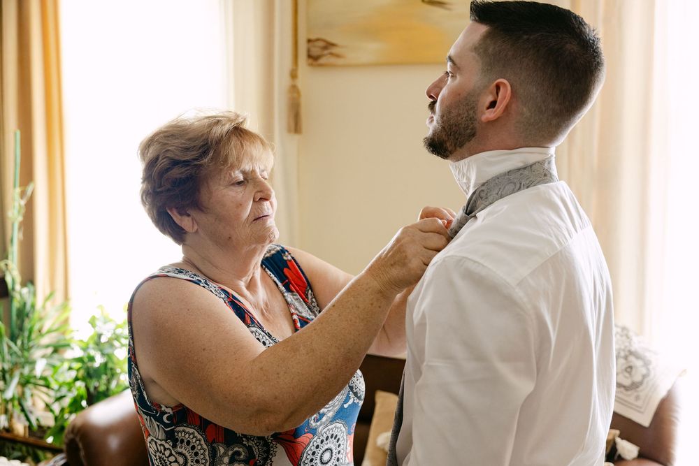 Emotional moment between groom and grandparents during wedding preparations in Almada