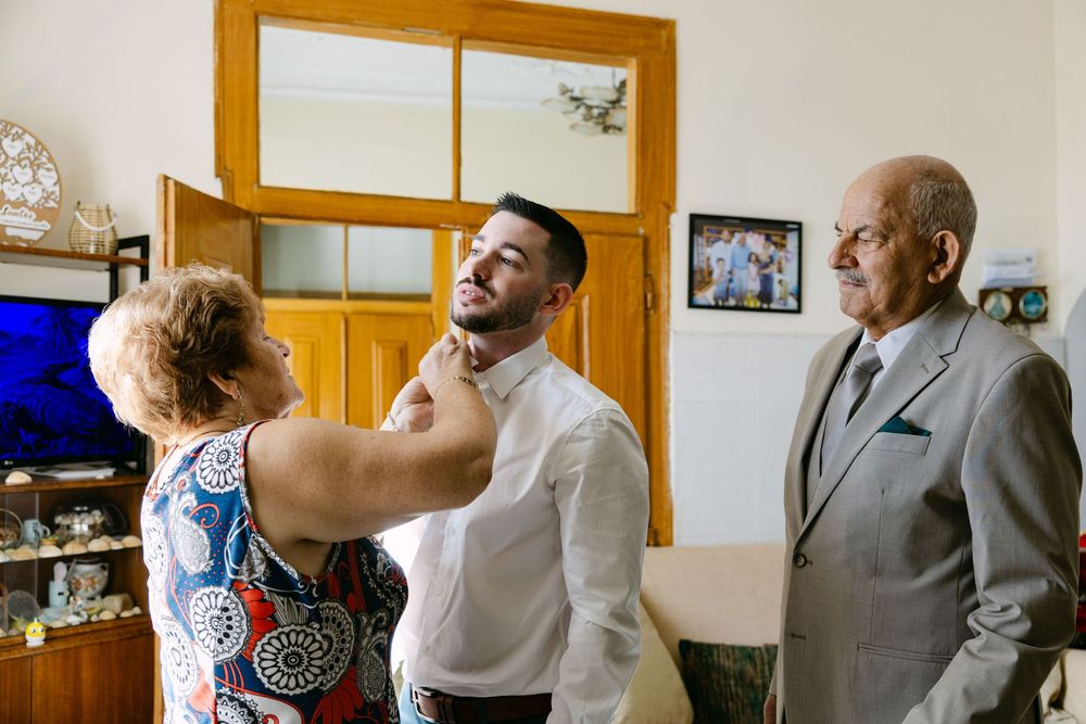 Groom getting ready in Almada surrounded by his grandparents on the morning of the wedding