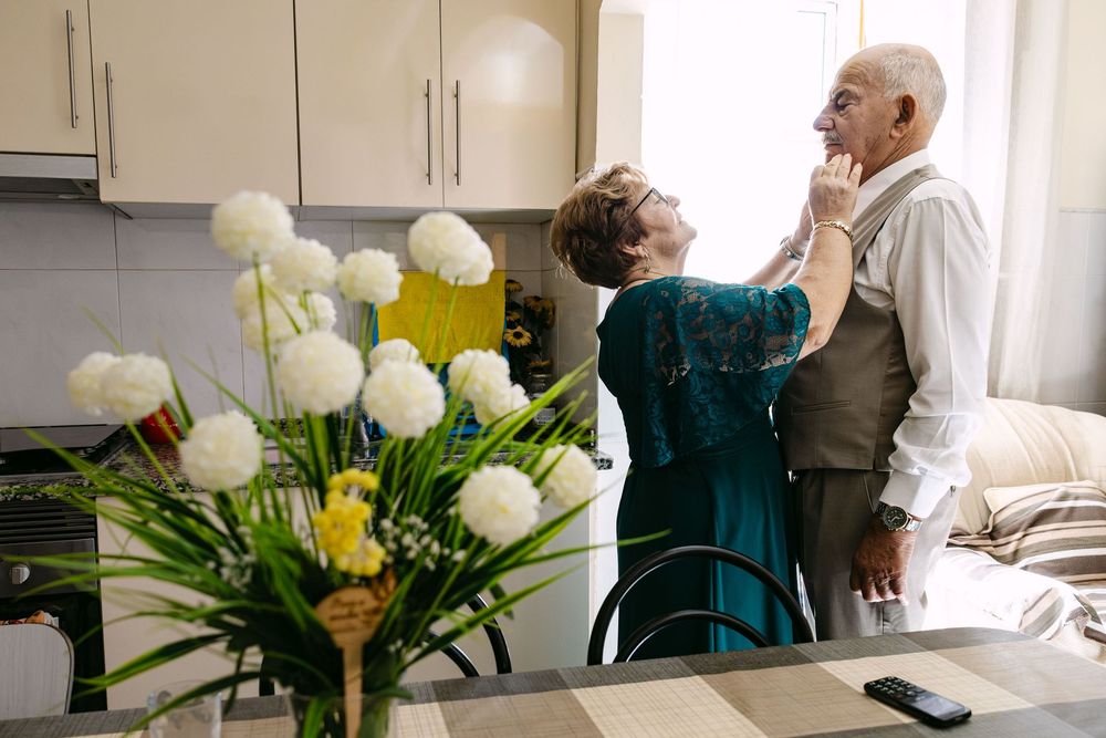 Intimate family interaction during groom preparations in a home setting in Almada.