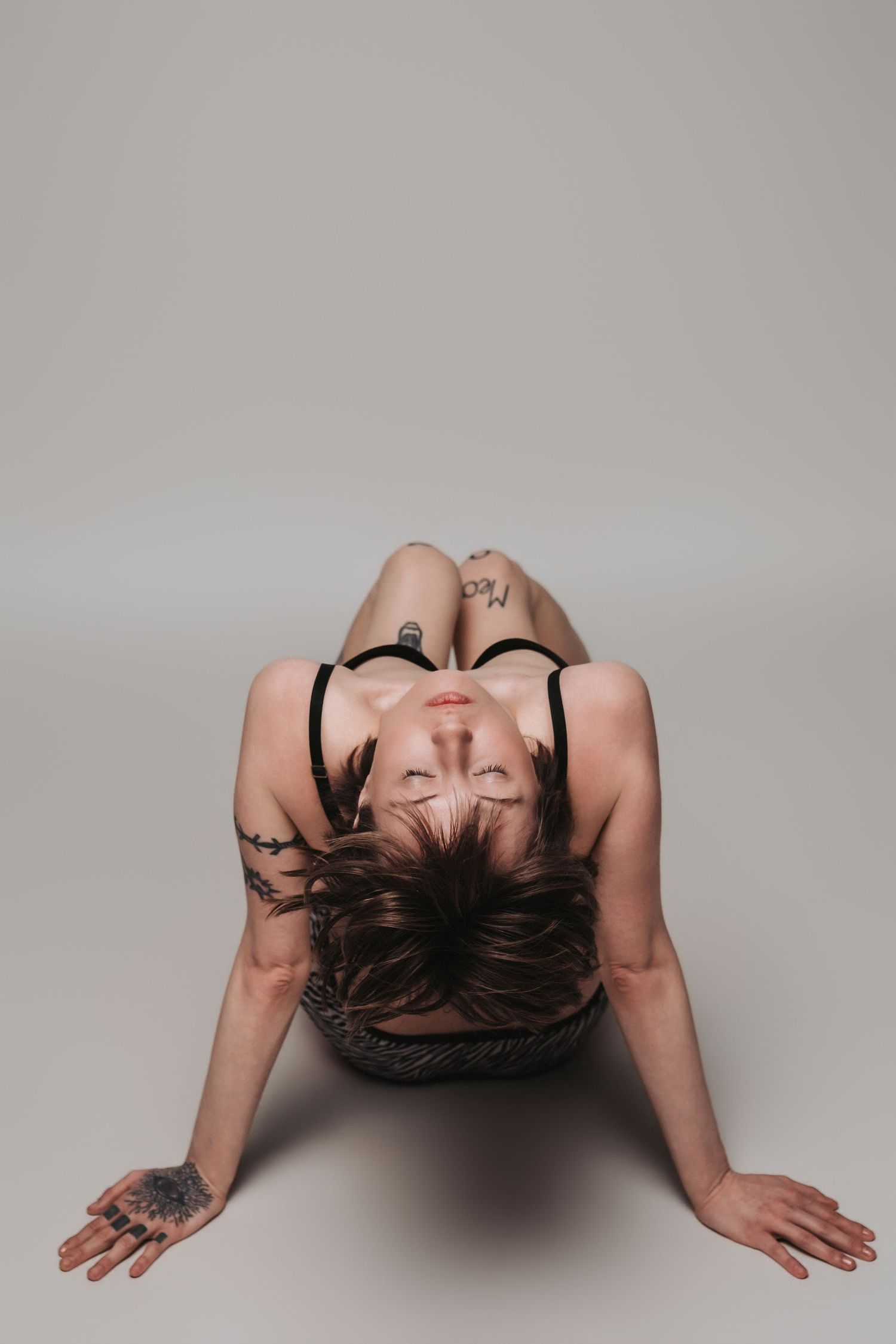 A series of artistic black and white portraits showing a figure laying back with dark hair against a light background.