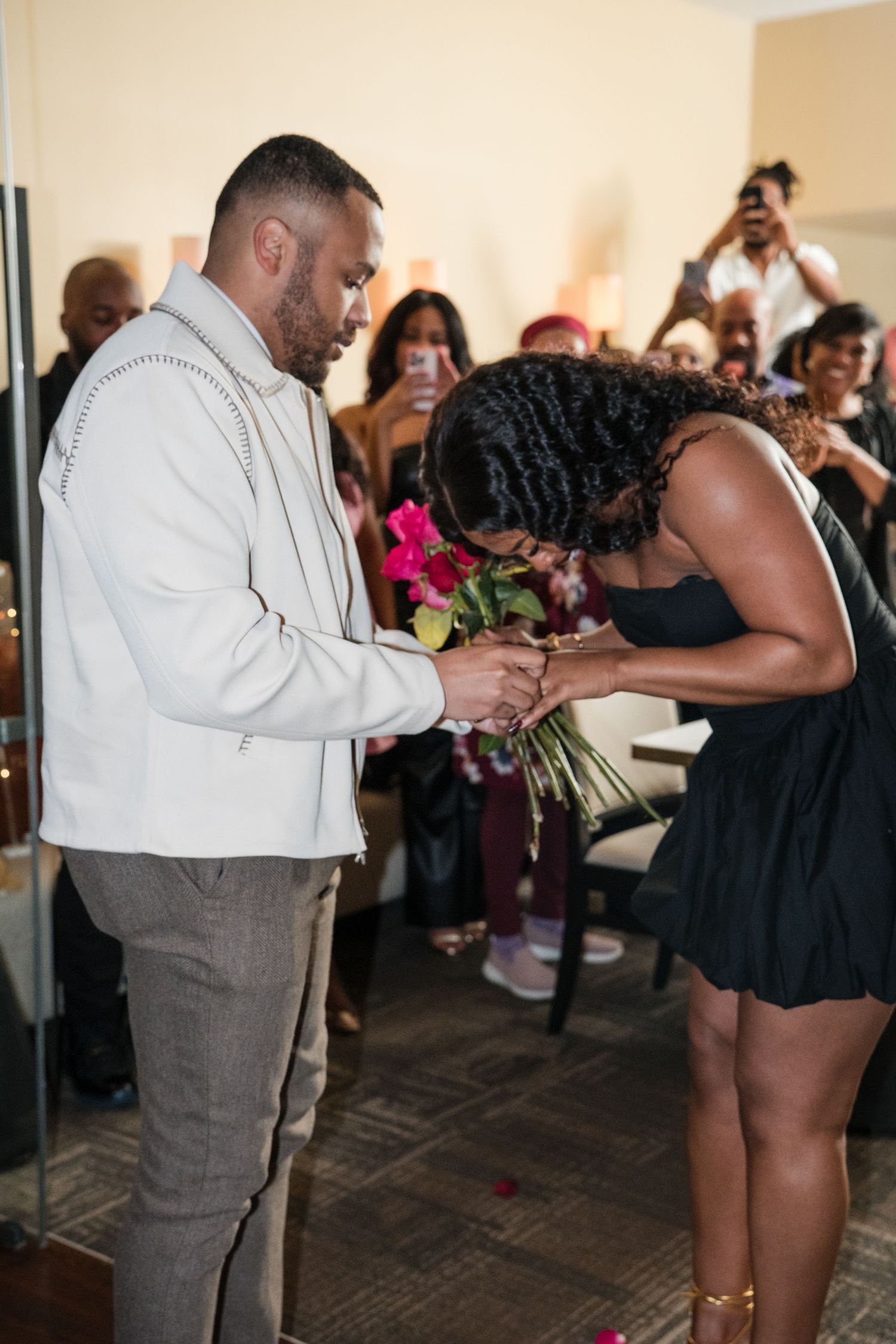 A romantic proposal sequence showing a couple during their special moment at an indoor celebration.