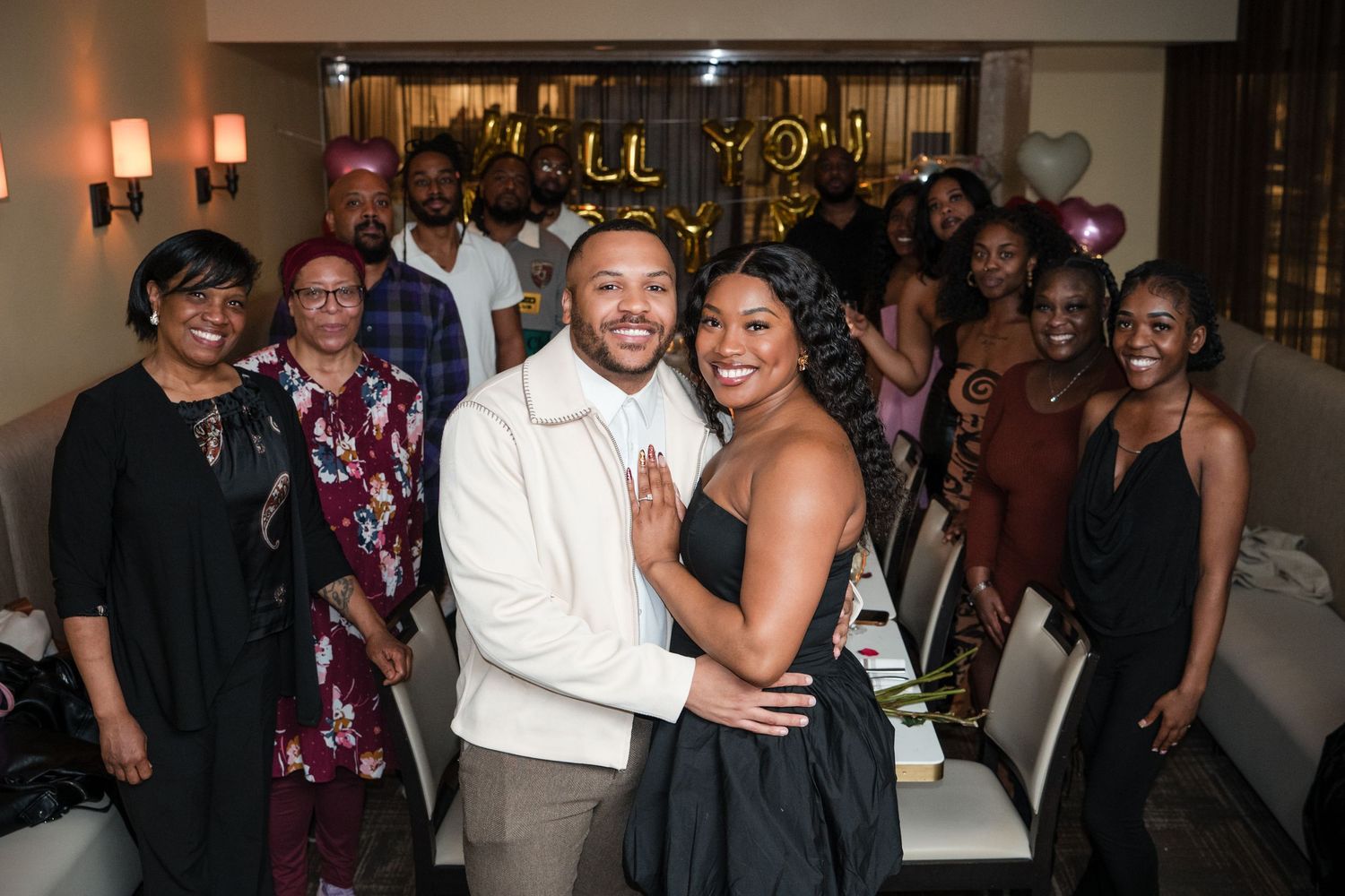 A group of wedding guests dance and celebrate together during an evening reception.
