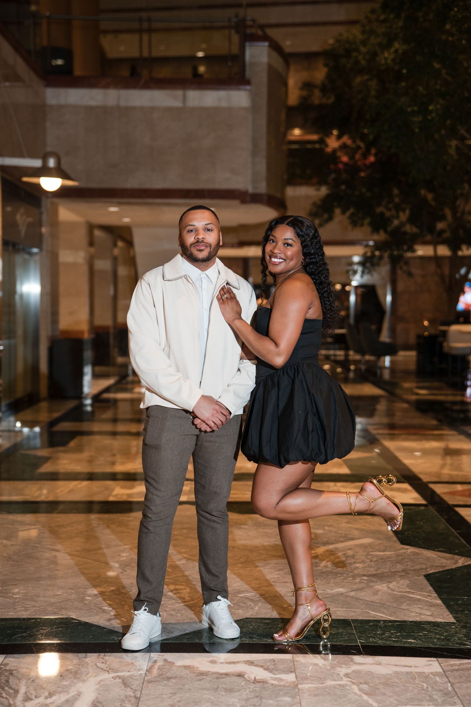 Romantic evening photoshoot in an elegant indoor venue with marble floors and ambient lighting.