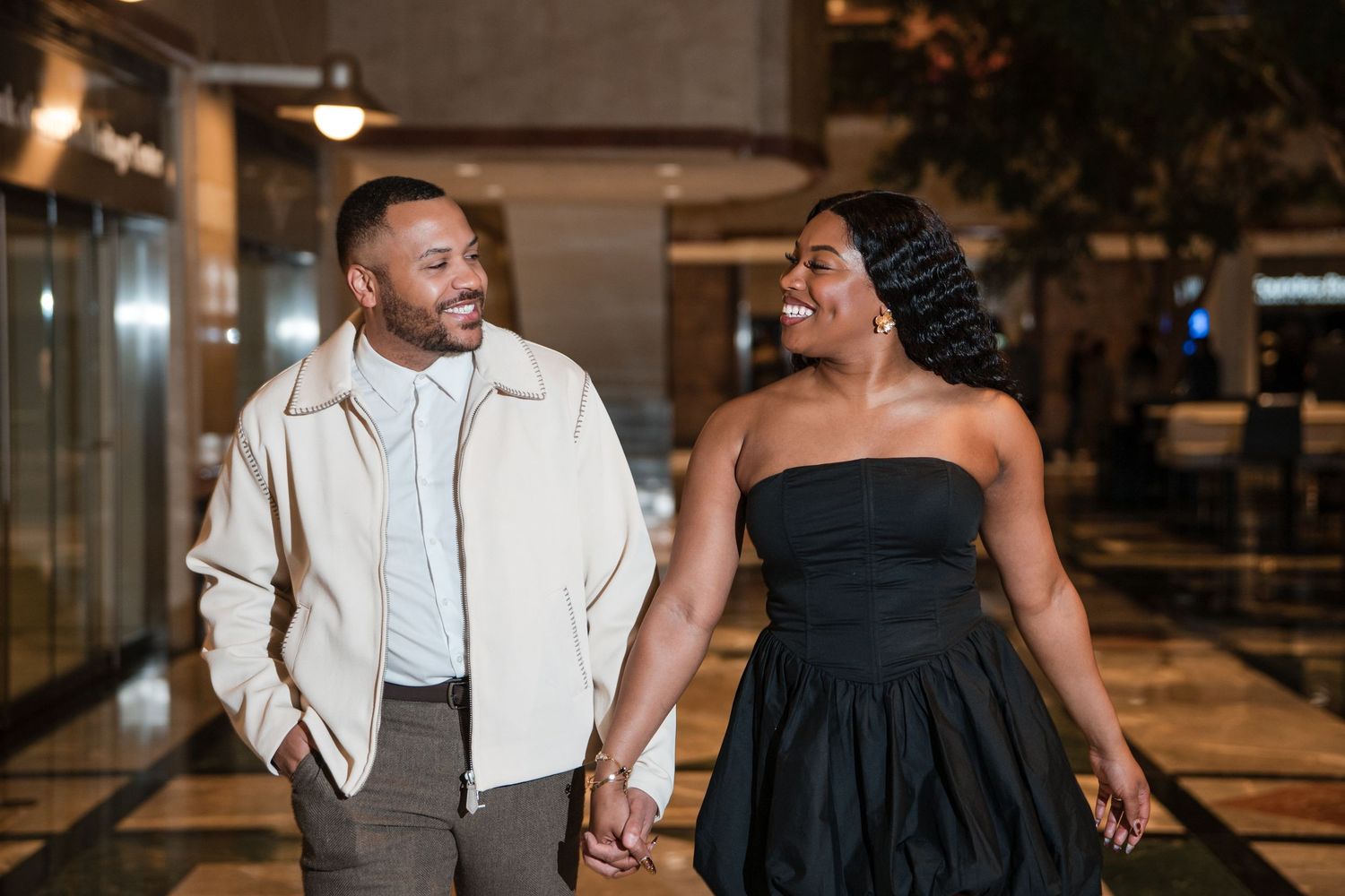 A couple shares an intimate dance moment on a wooden floor during their wedding reception.