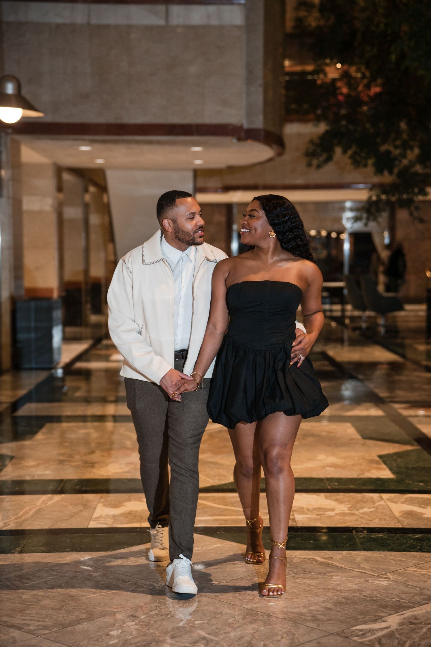 Couple dancing together on a marble floor in an elegant indoor venue.